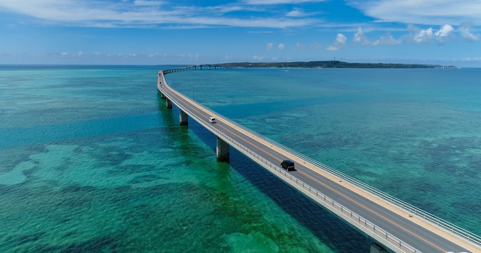 Vista aérea de un largo puente sobre aguas oceánicas azules