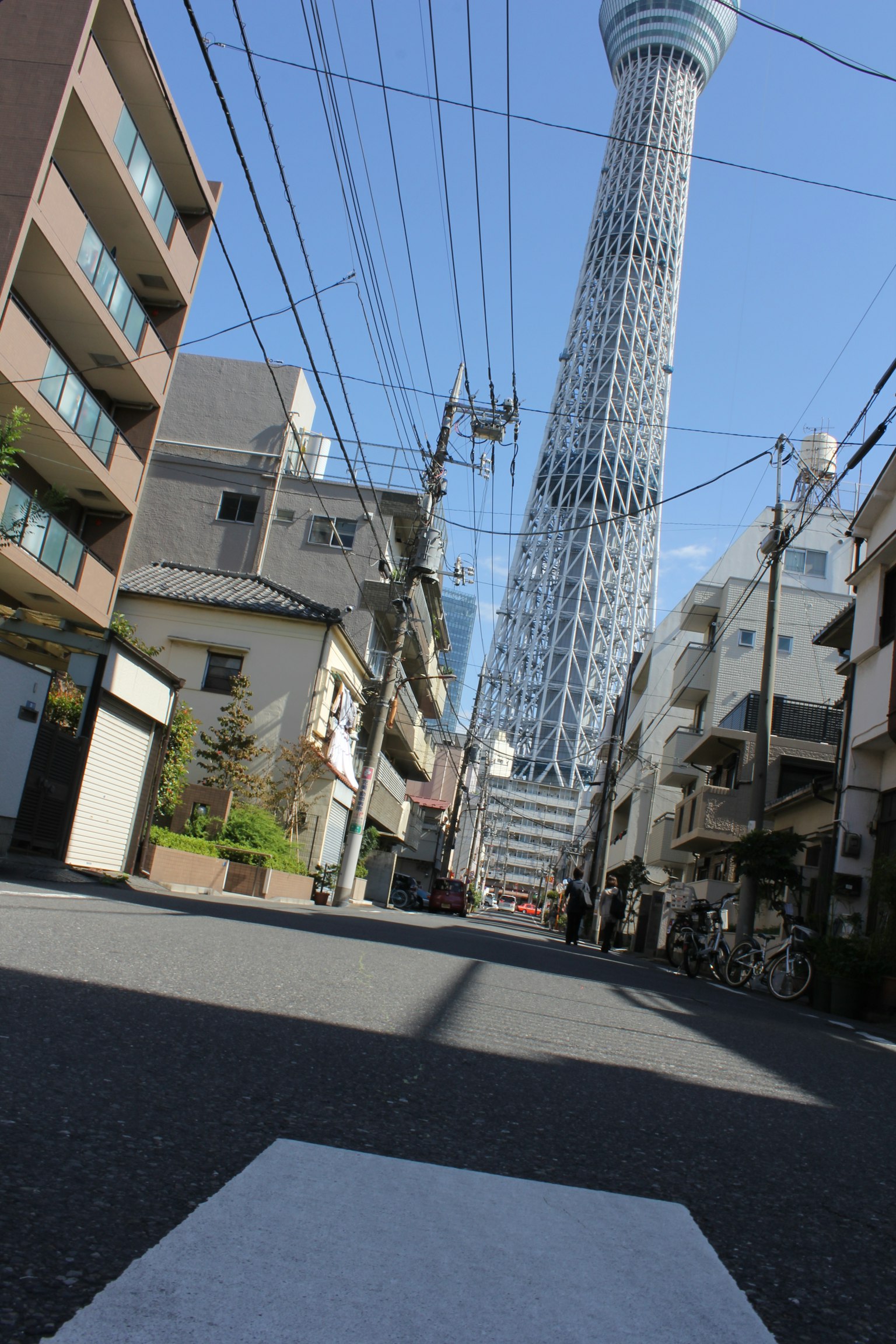 Blick auf den Tokyo Skytree von einer Straße mit Gebäuden