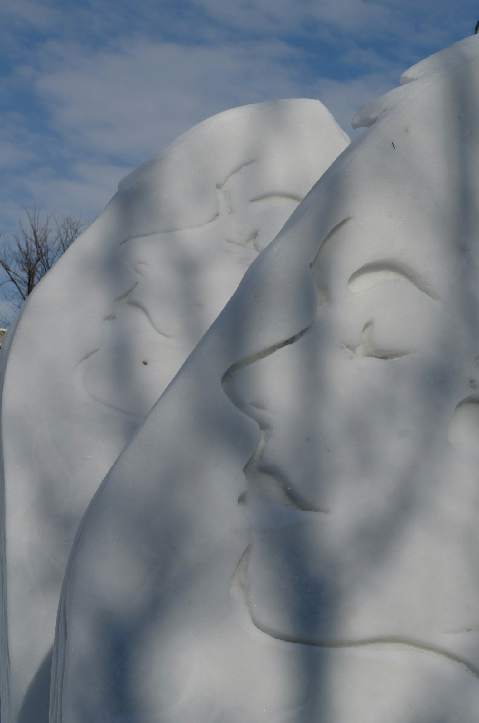 Close-up of white sculpted faces with soft contours and shadows