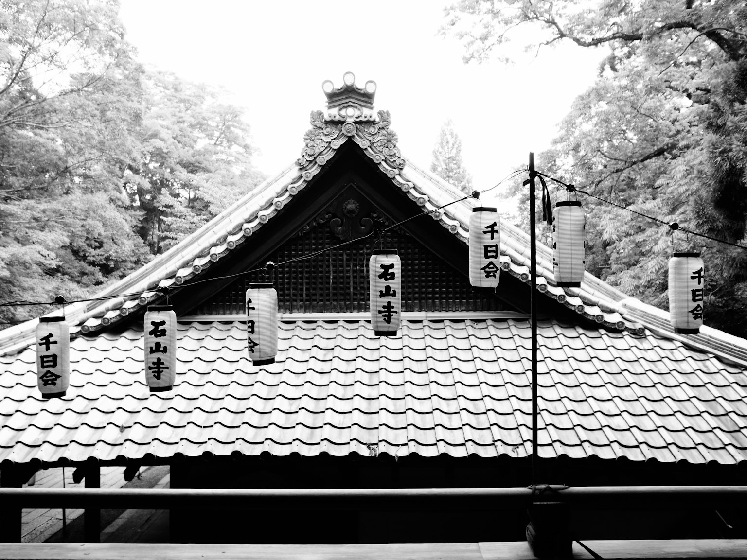 오래된 사원의 지붕에 매달린 랜턴과 기와 디자인