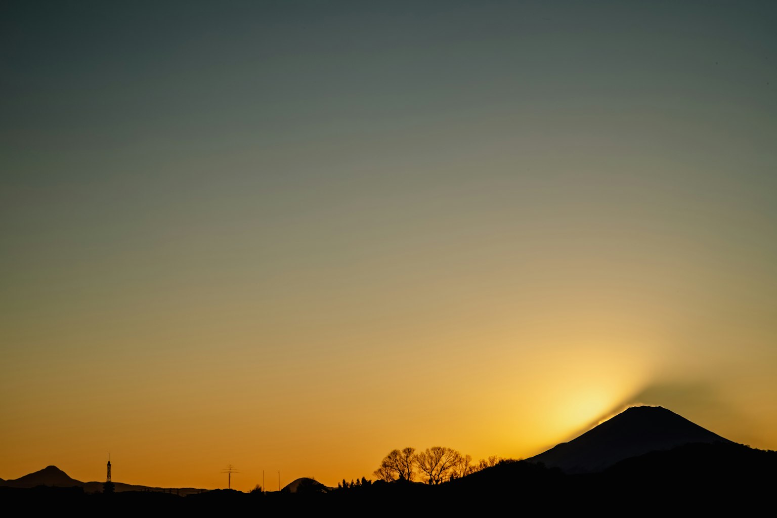 Silhouette di una montagna contro un tramonto colorato