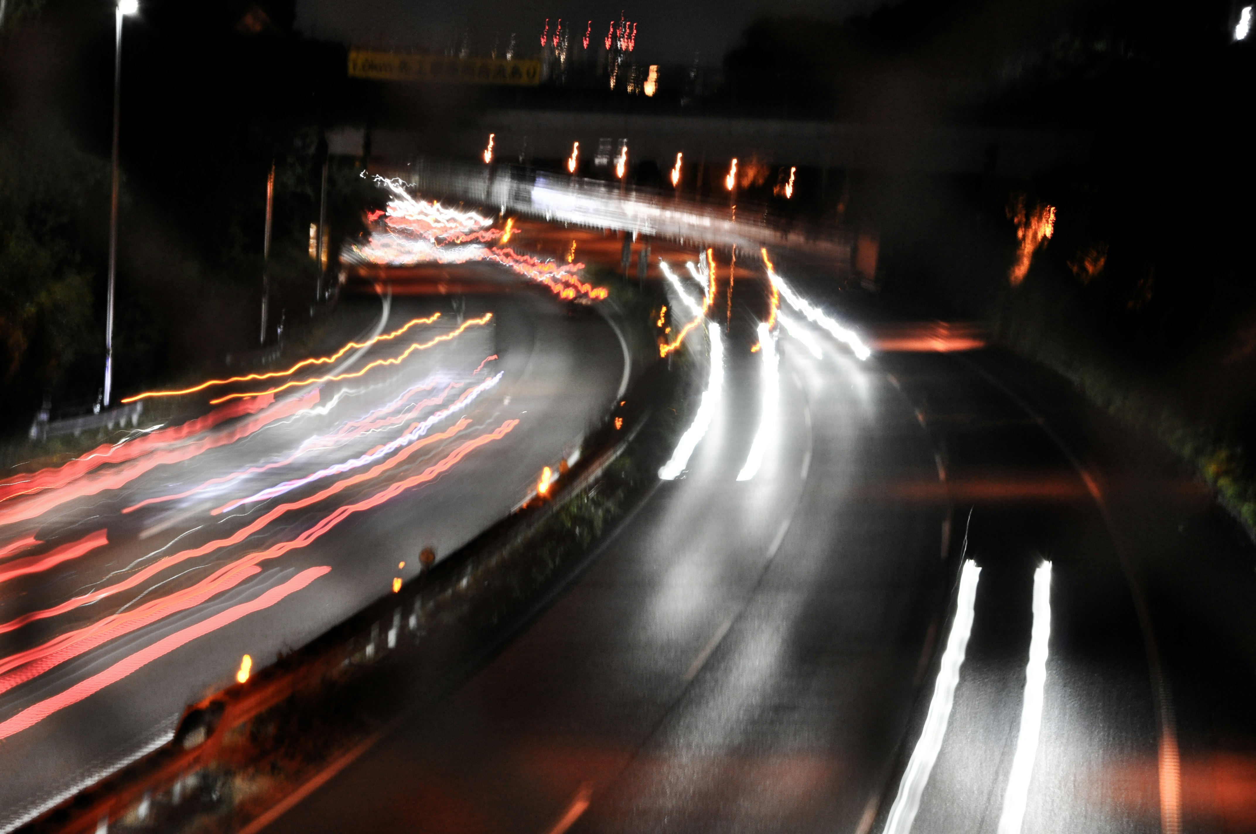 夜の高速道路を走る車の光跡