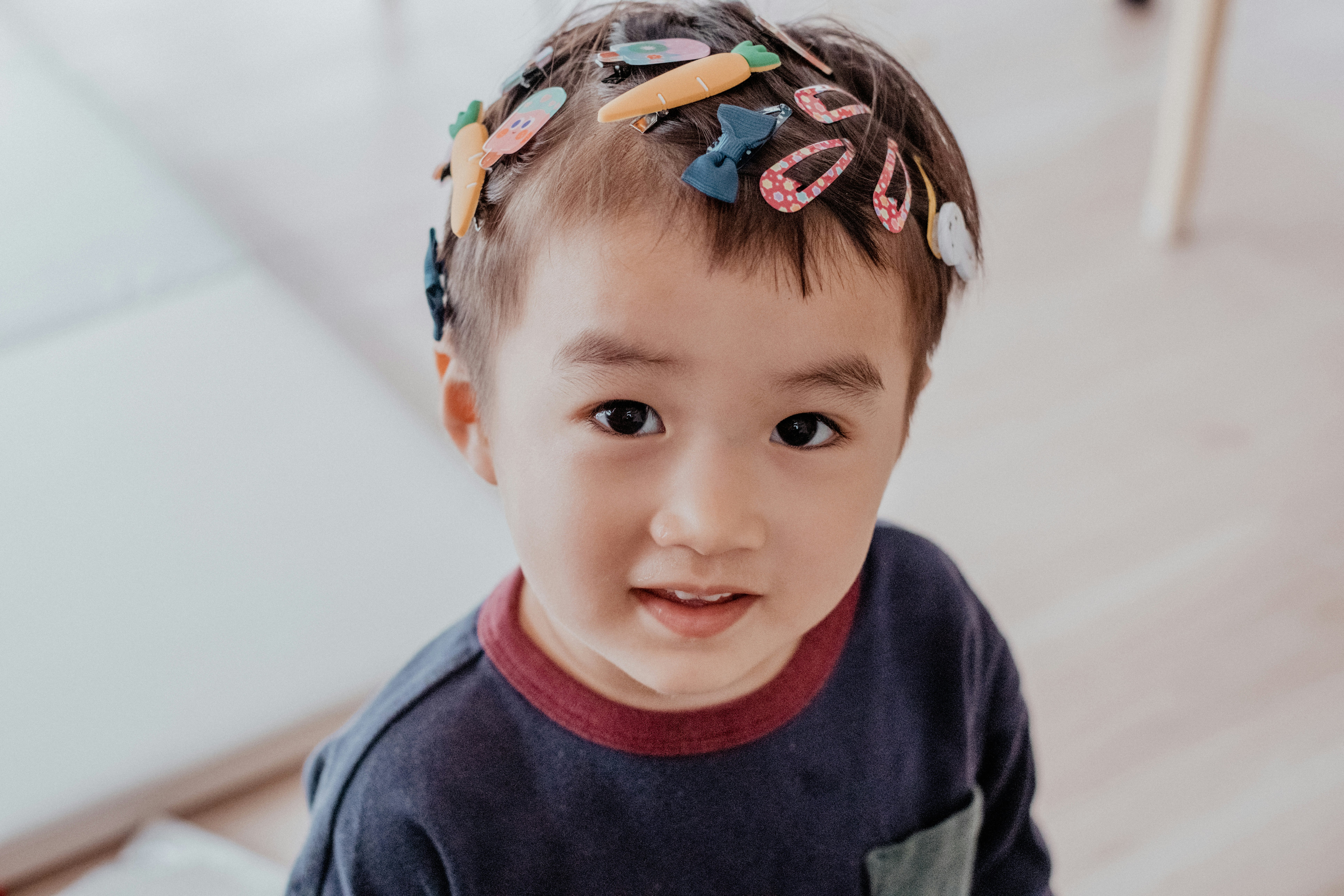 sourire d’un jeune garçon avec des barrettes colorées