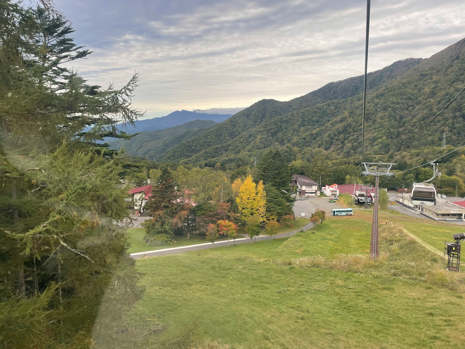 Scenic view from a gondola overlooking mountains and a small town
