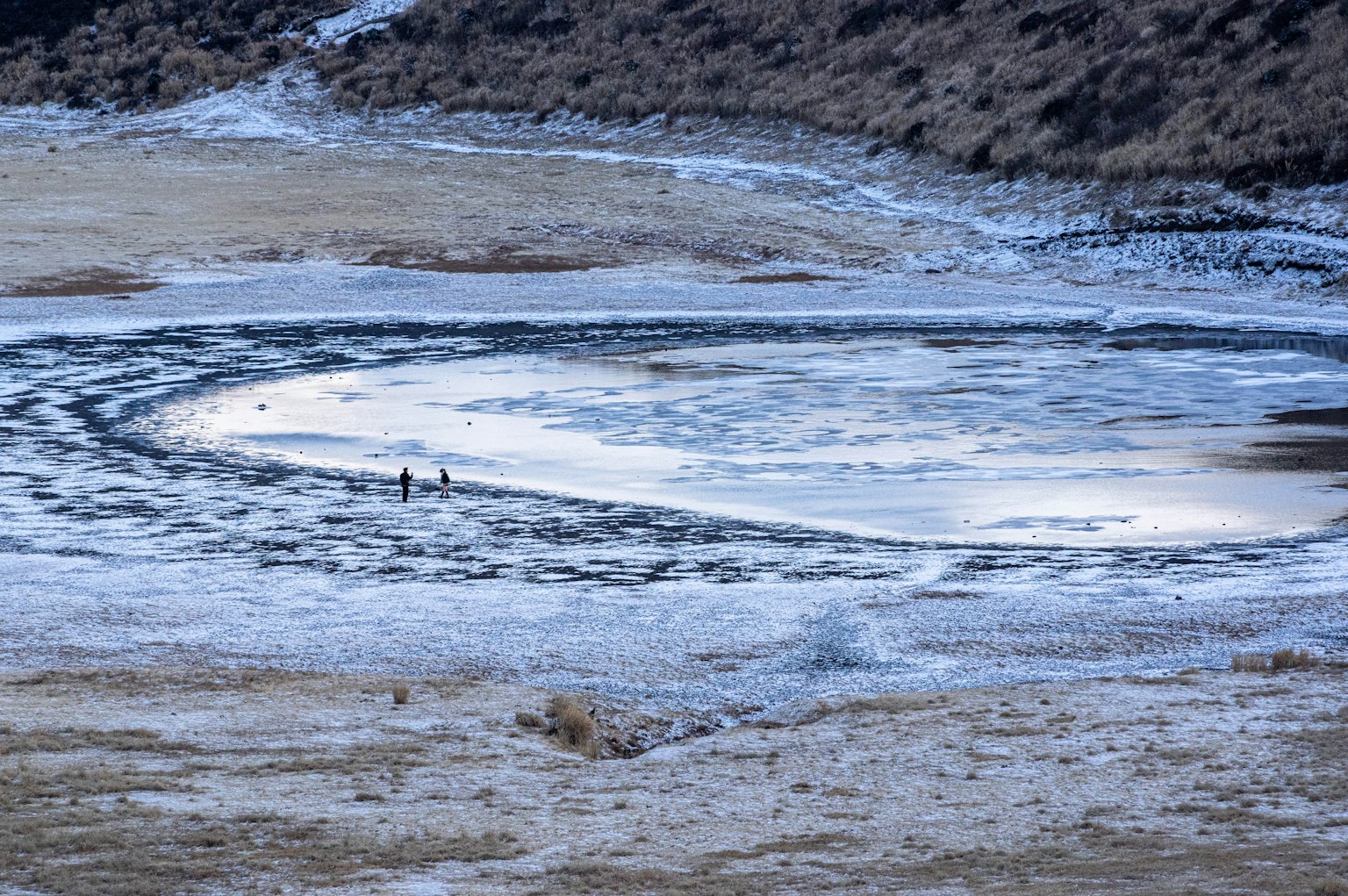 凍った湖の周囲に広がる雪と氷の模様