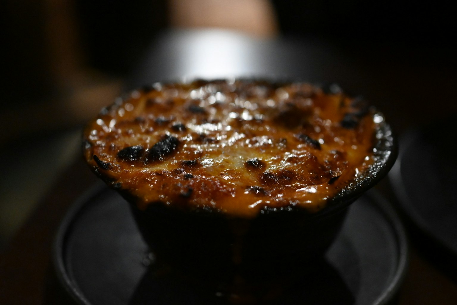 Dish with a browned cheese topping and creamy sauce