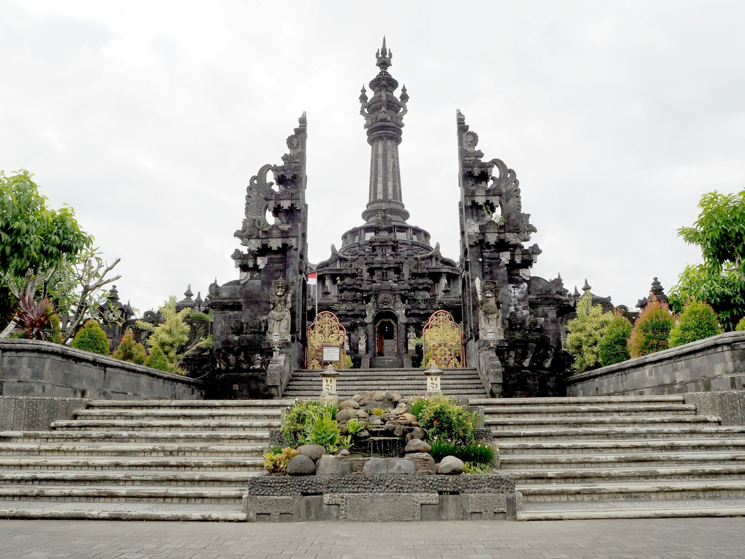 Grand entrance of a temple in Bali featuring stone steps and lush greenery