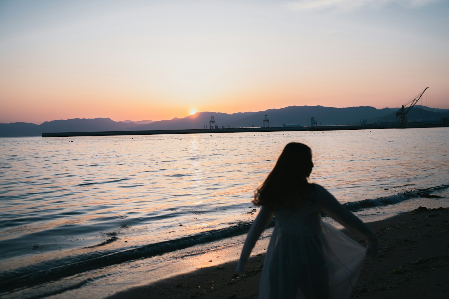 海邊夕陽下的女性剪影