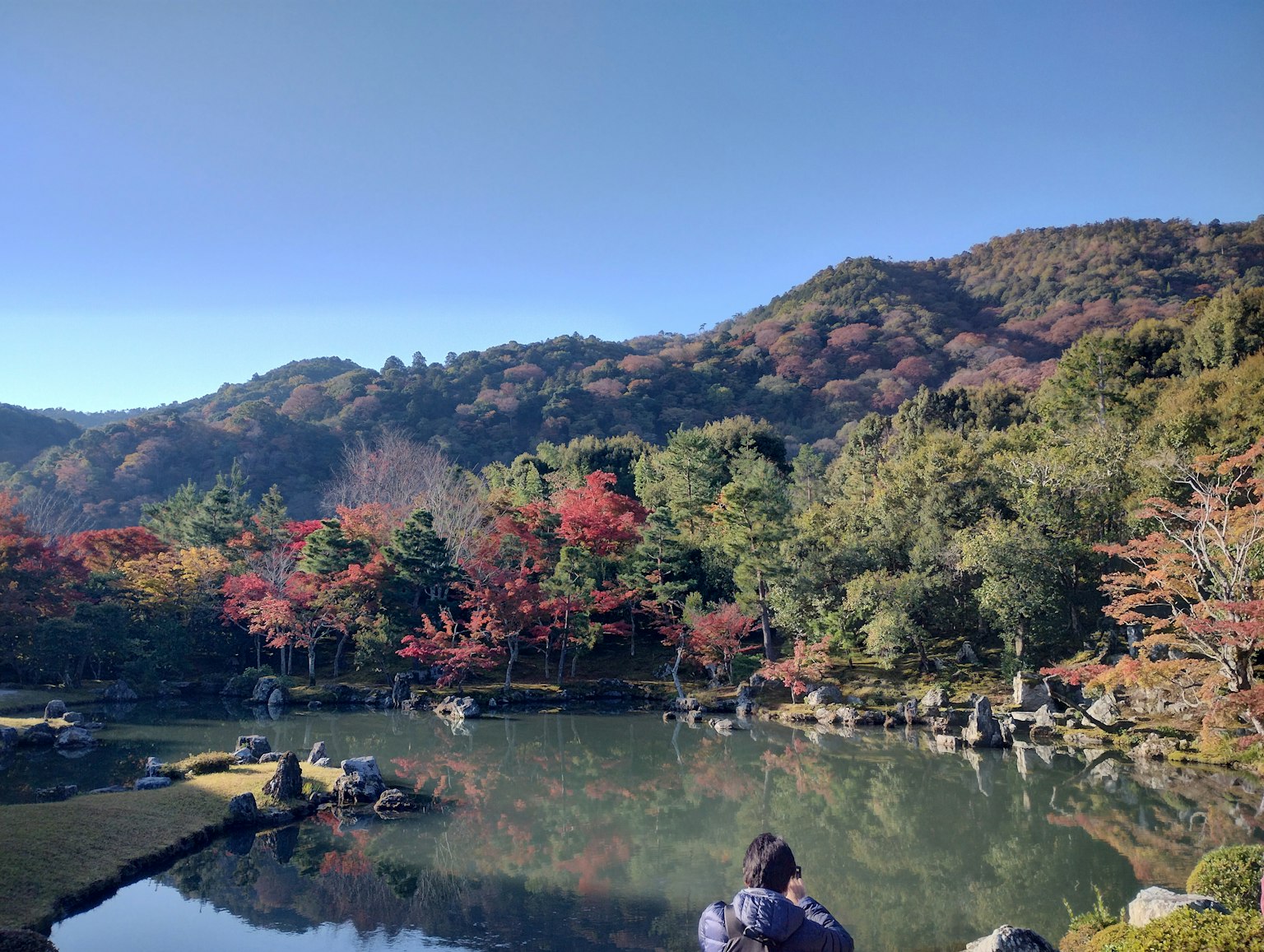 Serene pond reflecting autumn foliage and mountains
