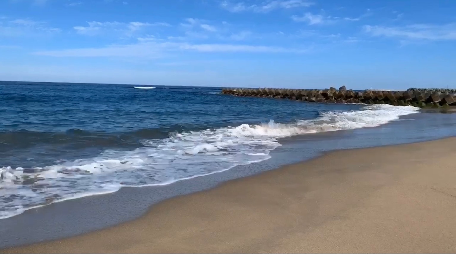 Scenic view of a beach with blue ocean and white waves