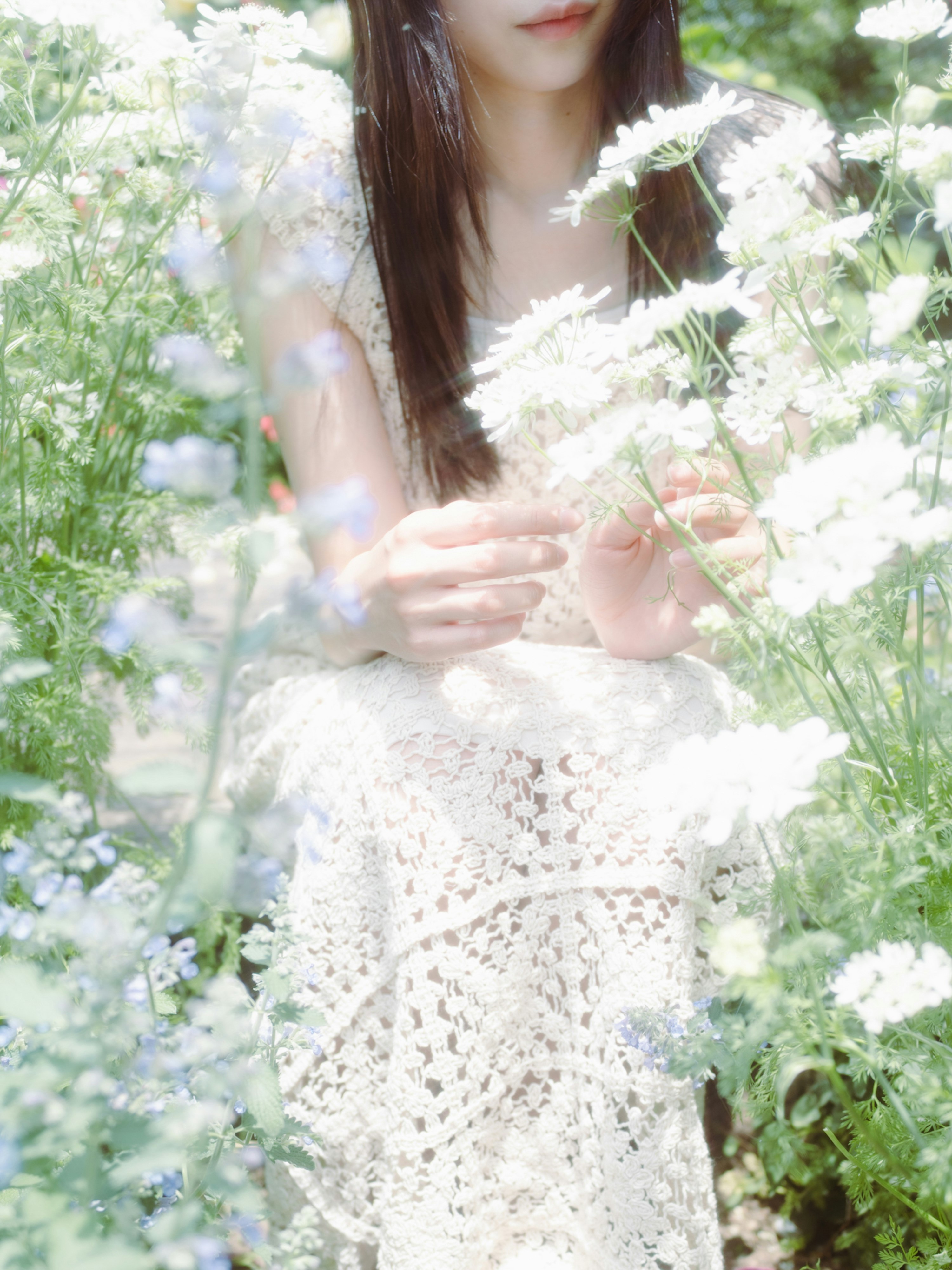 花が咲く庭で花を見つめる友人と色とりどりの花々
