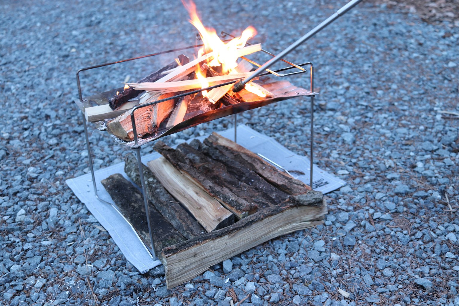 Pengaturan api unggun kecil dengan kayu bakar dan api