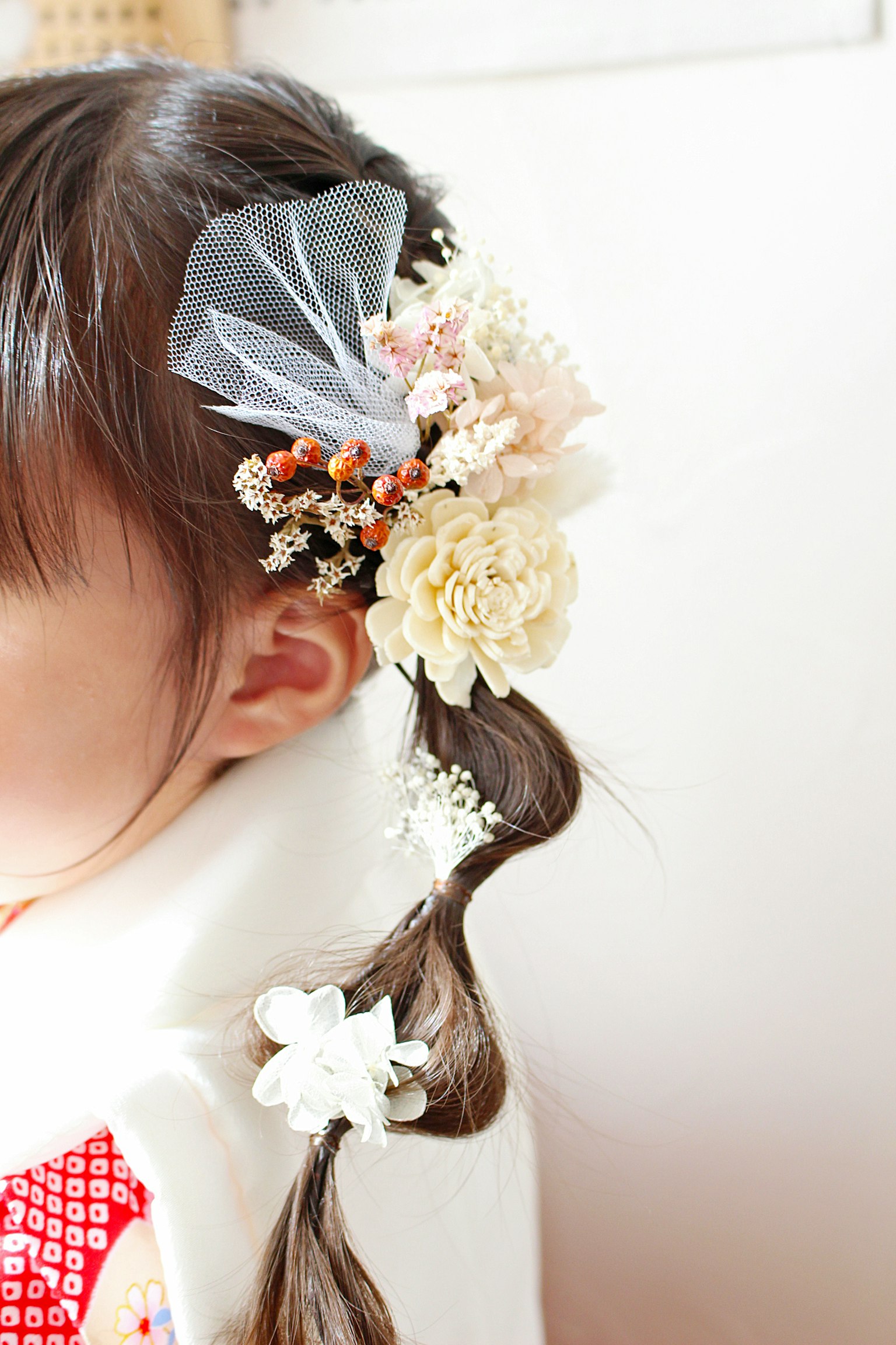 Acconciatura per bambini decorata con fiori e accessori in nastro