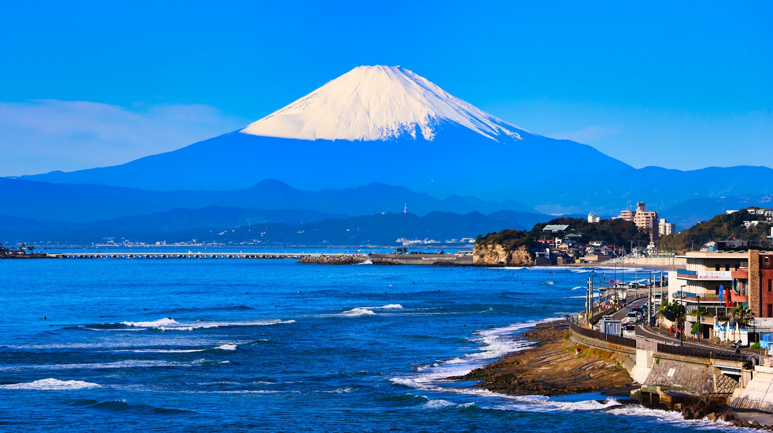 Mont Fuji s'élevant sous un ciel bleu avec un paysage côtier