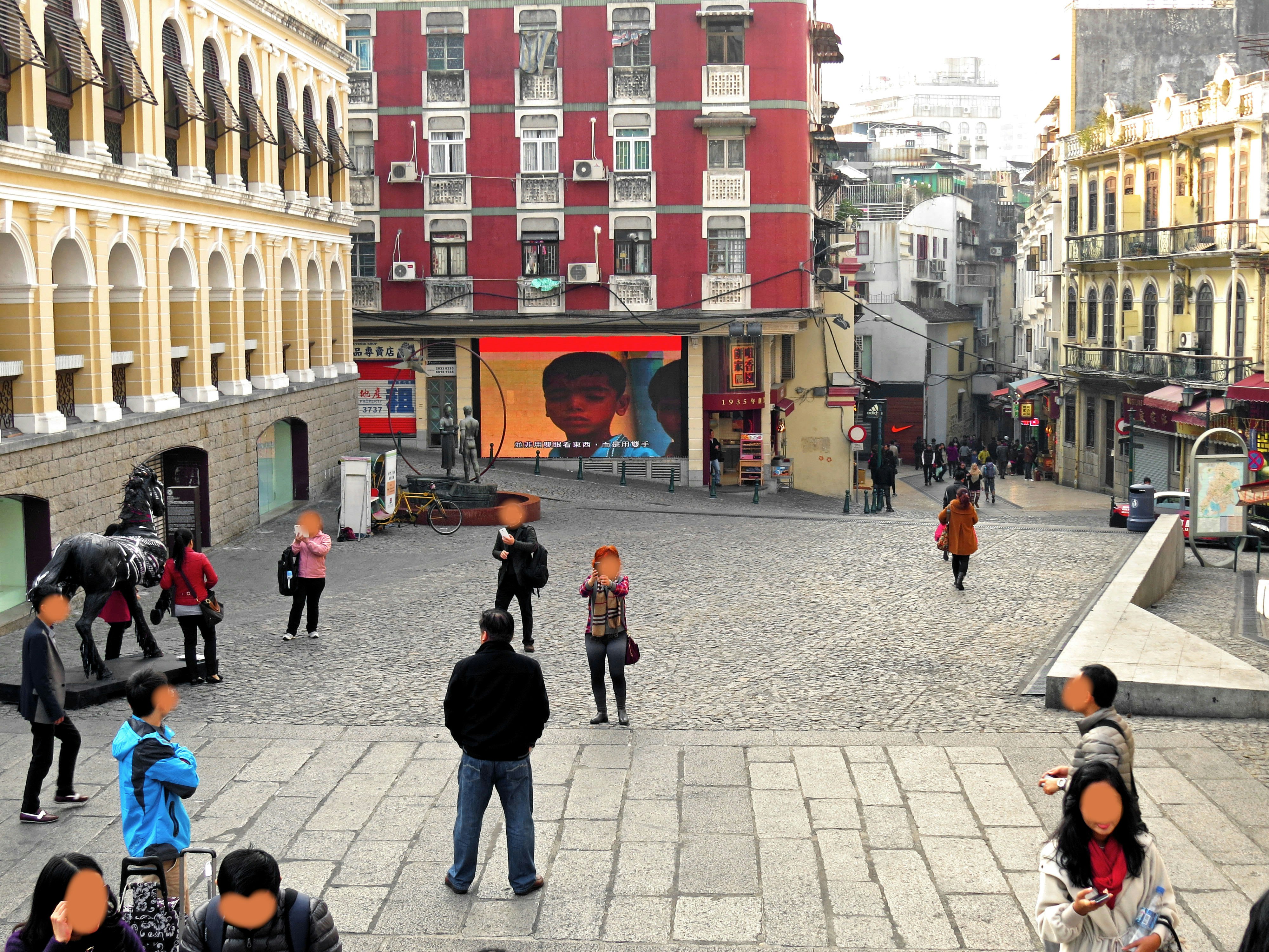 Calle empedrada con arcos tipo galería y fachadas coloridas