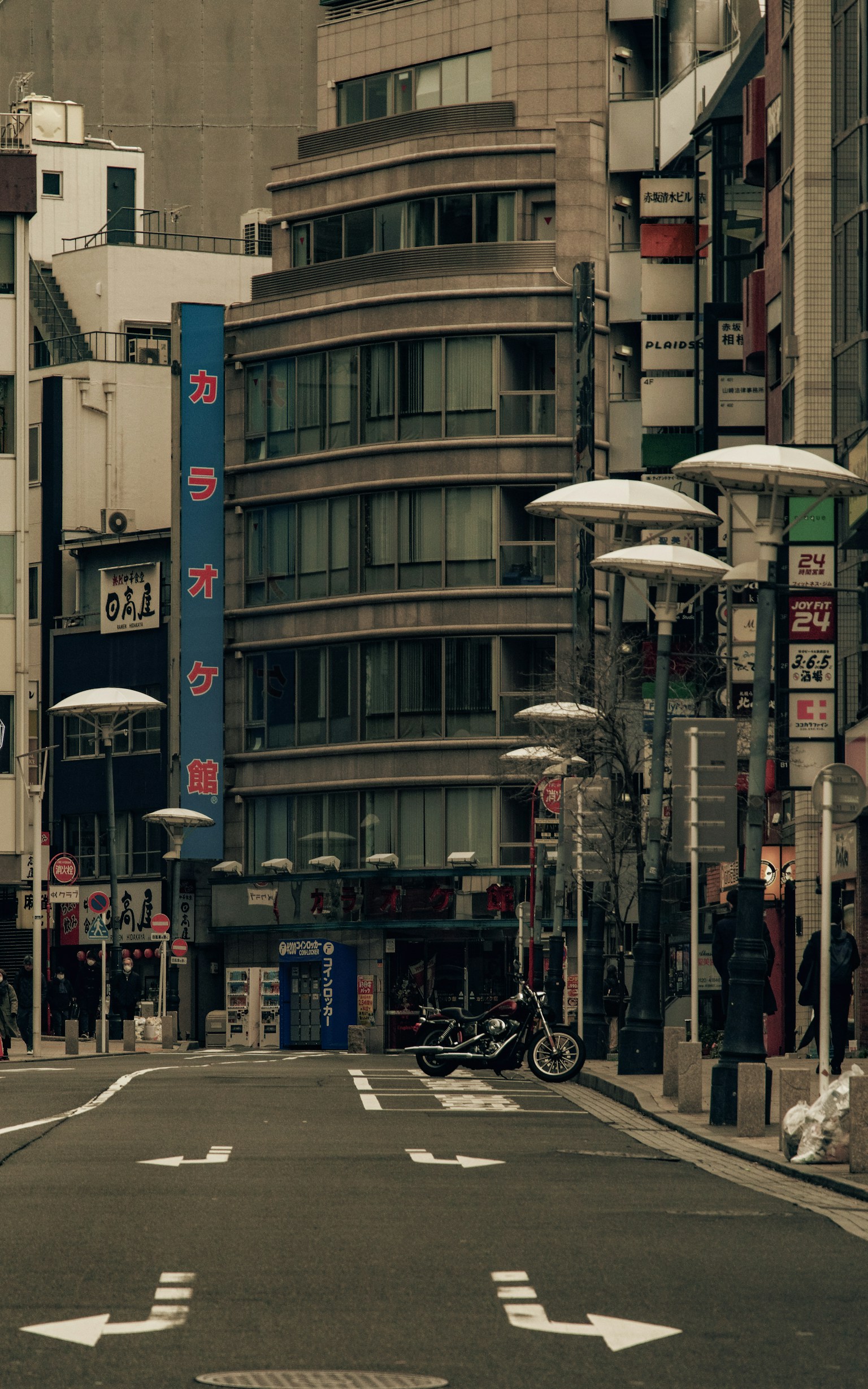 Quiet urban street featuring modern buildings and streetlights