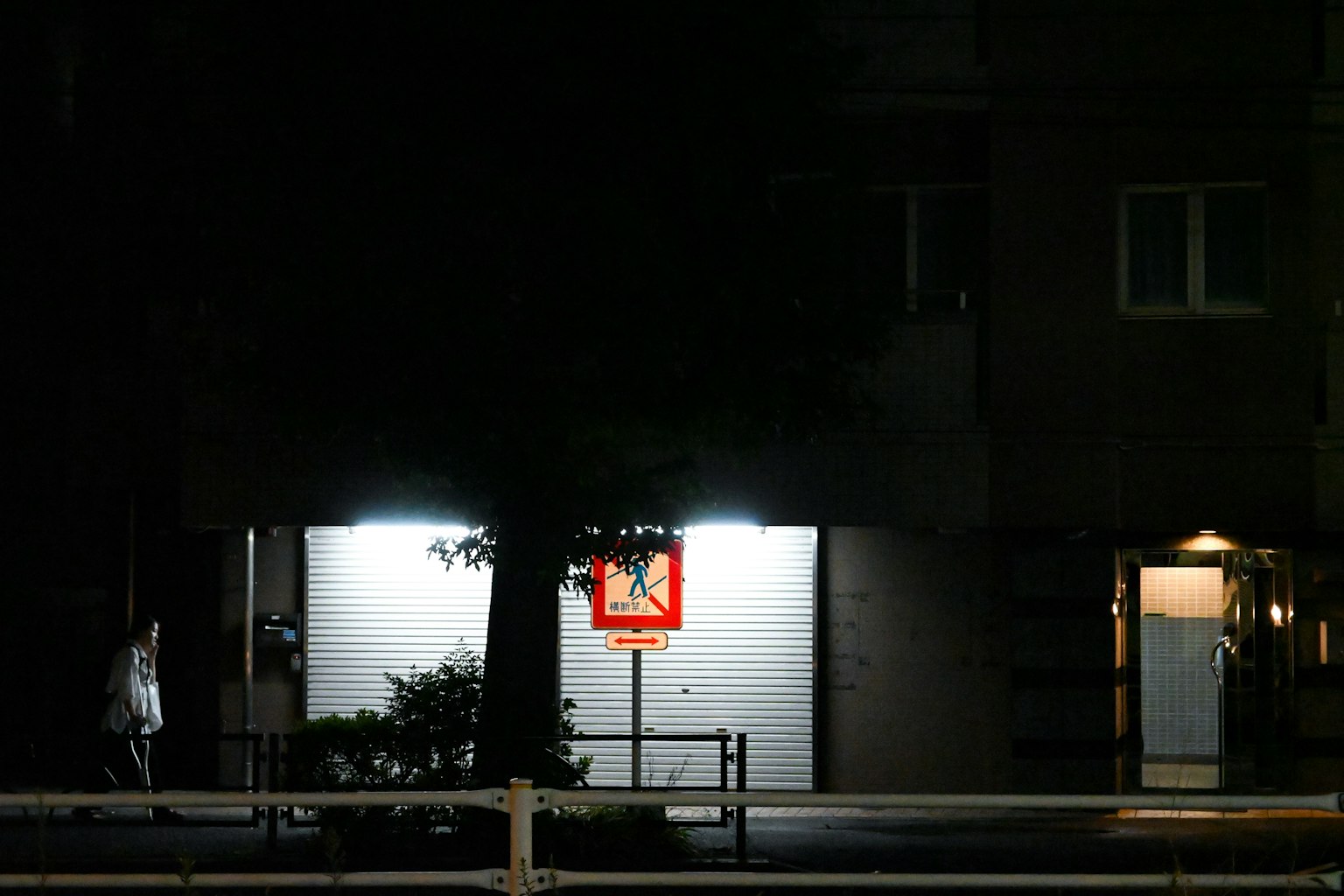 Escena nocturna de una cancha de baloncesto con edificio iluminado