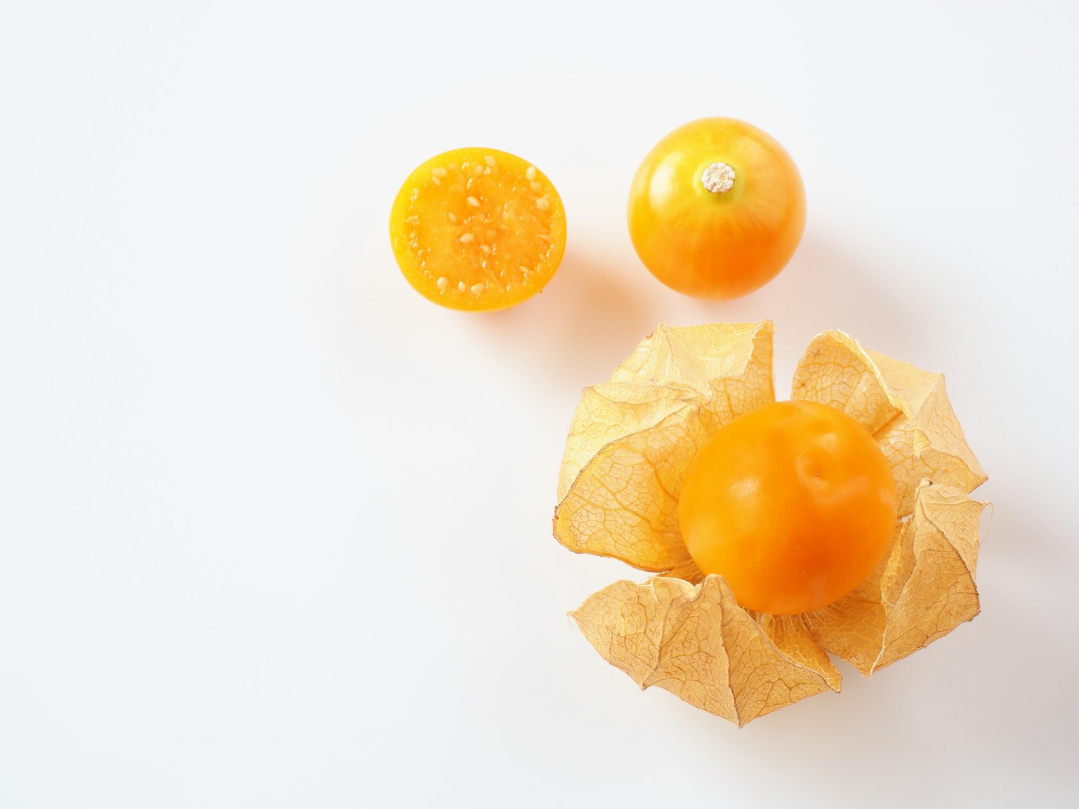Fruit orange avec une coque pelée et une moitié coupée sur un fond blanc