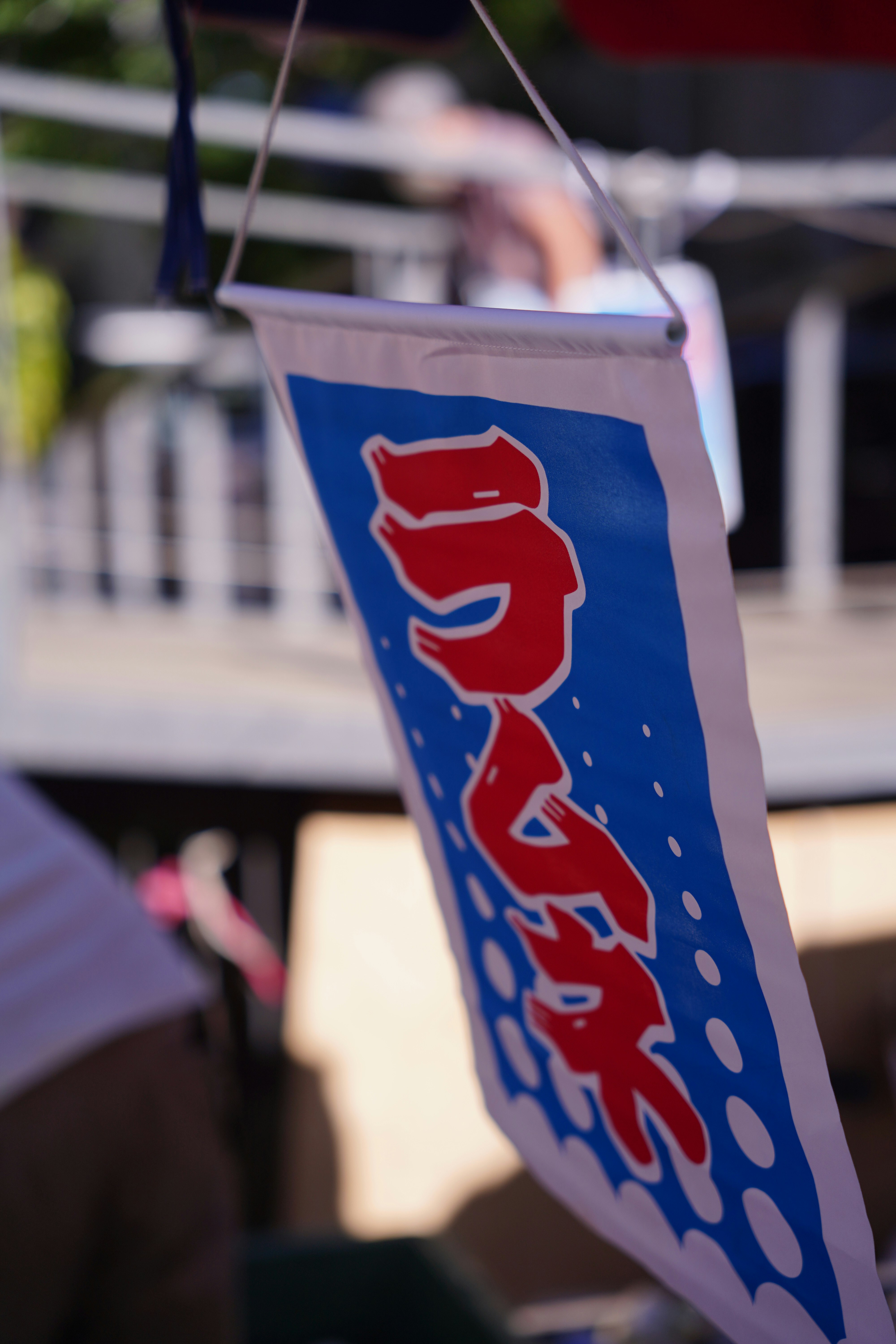 drapeau bleu et rouge suspendu devant un stand en extérieur