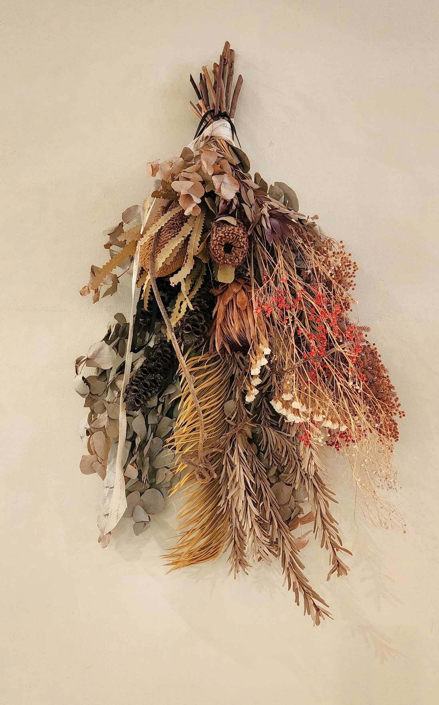 A bouquet of dried flowers hanging on a wall