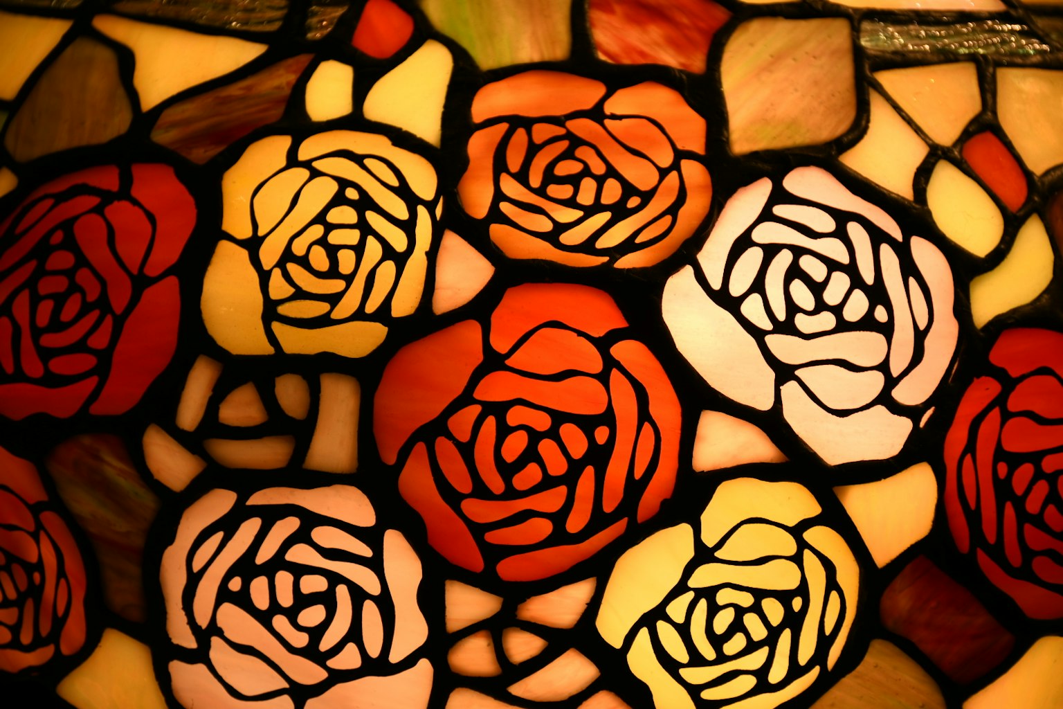Primo piano di una vetrata con rose colorate motivi intricati e tonalità vivaci