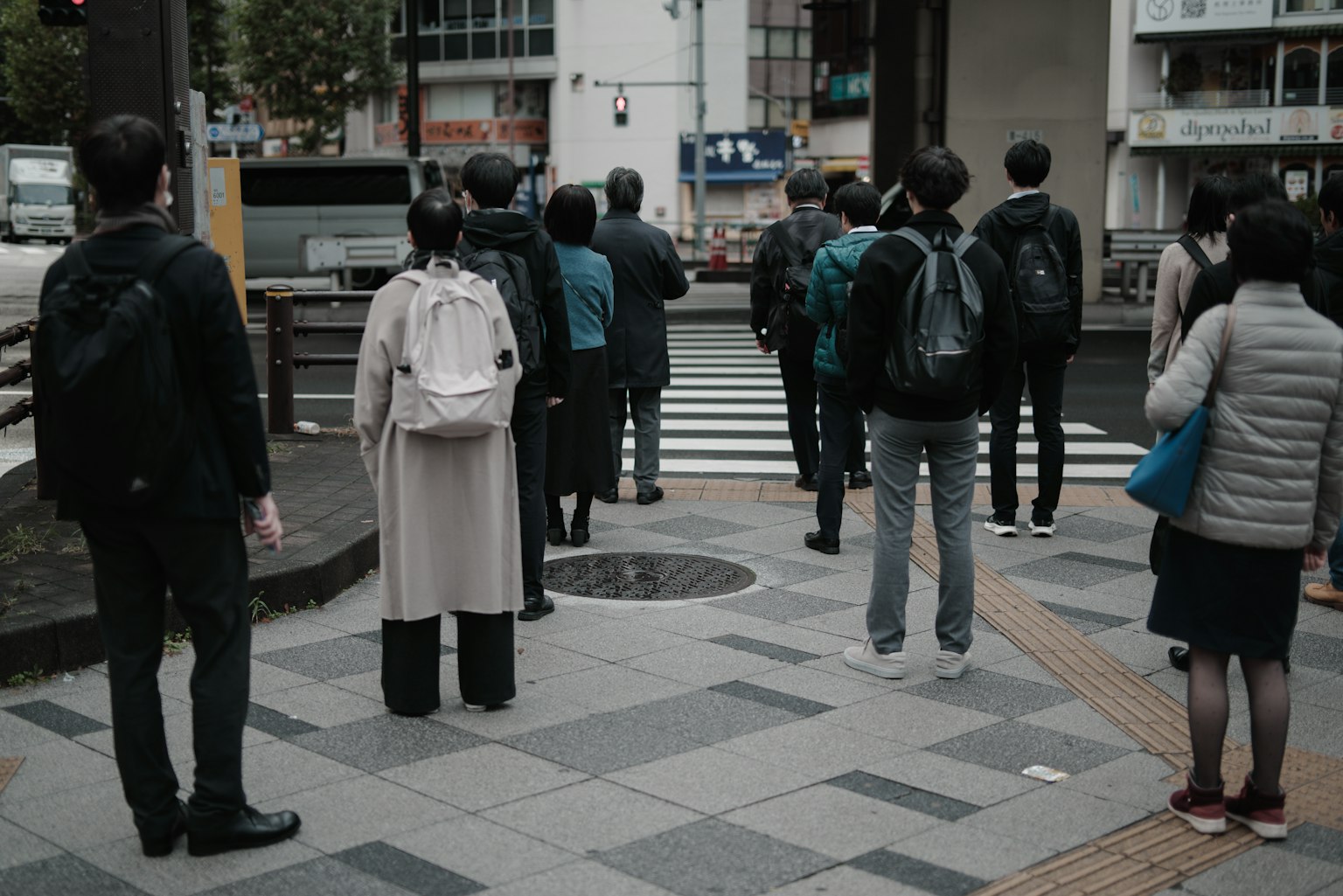 Foule de personnes attendant à un passage pour piétons avec un paysage urbain