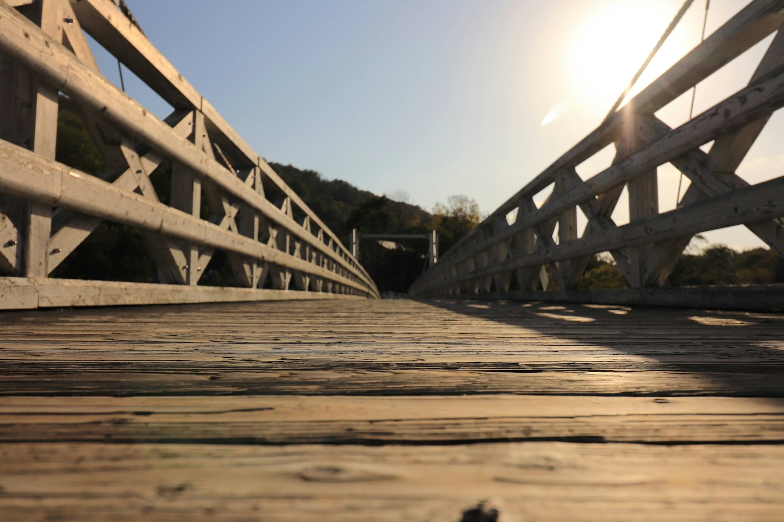 Aufsicht auf eine Holzbrücke mit Sonnenlicht