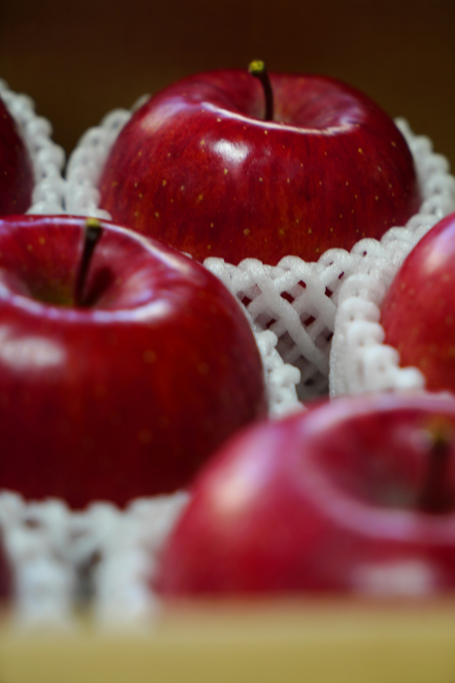 Red apples wrapped in white netting