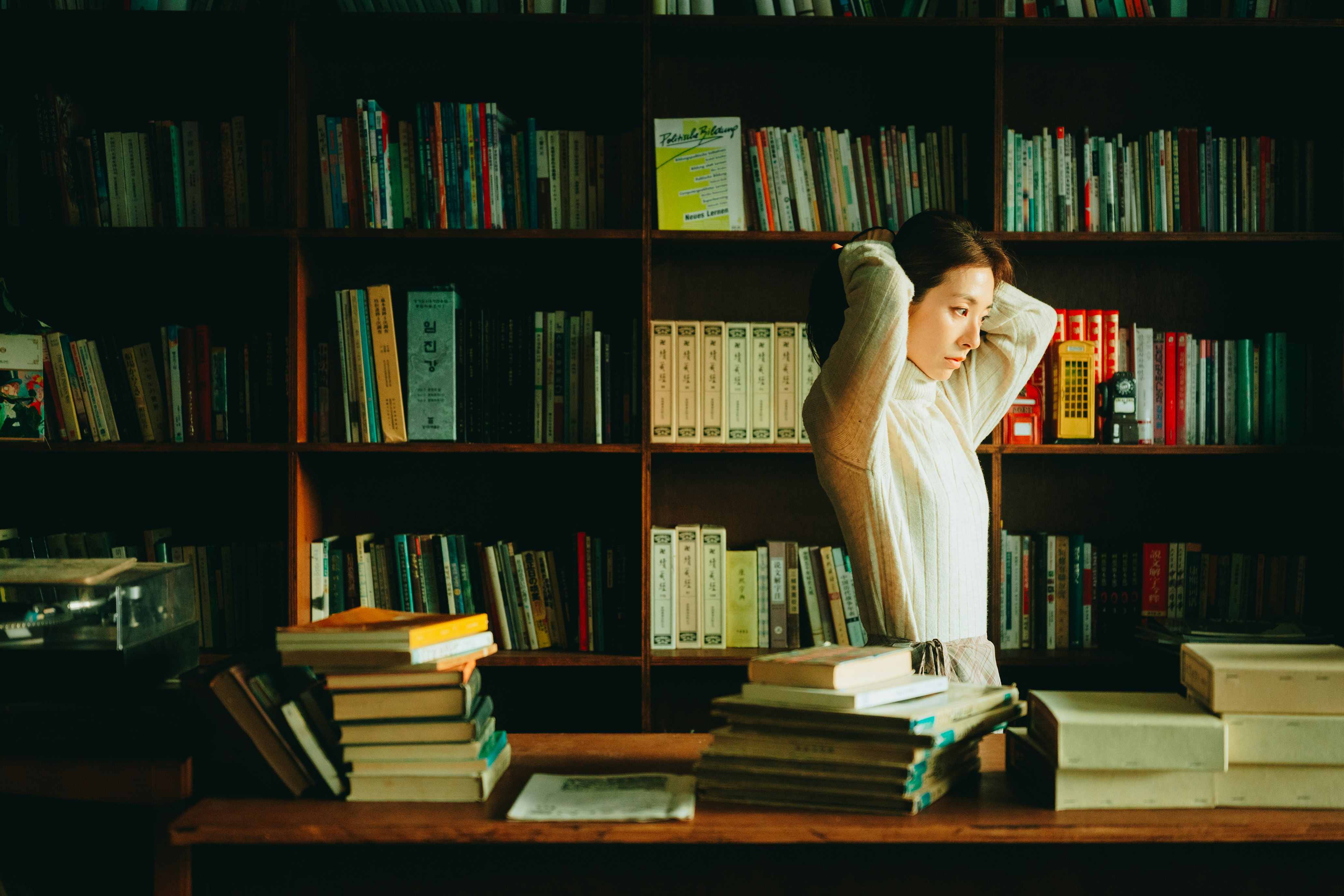 本棚のある書店で本を探す女性