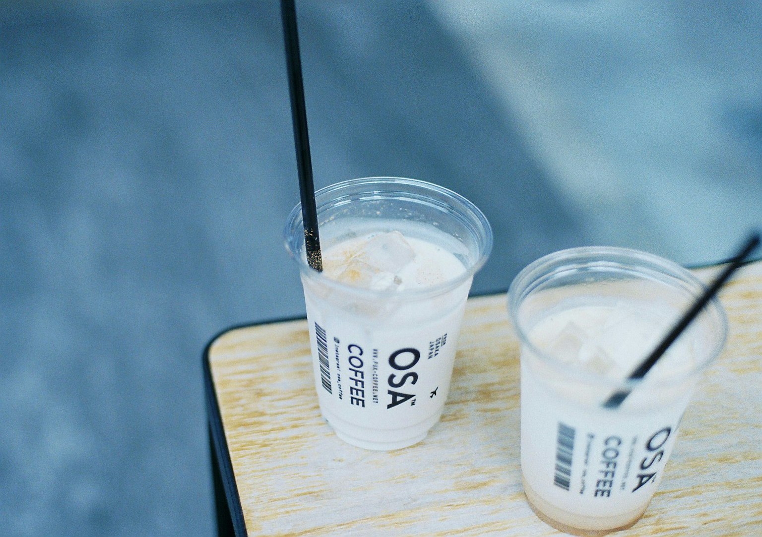 Two coffee drinks sitting on a table