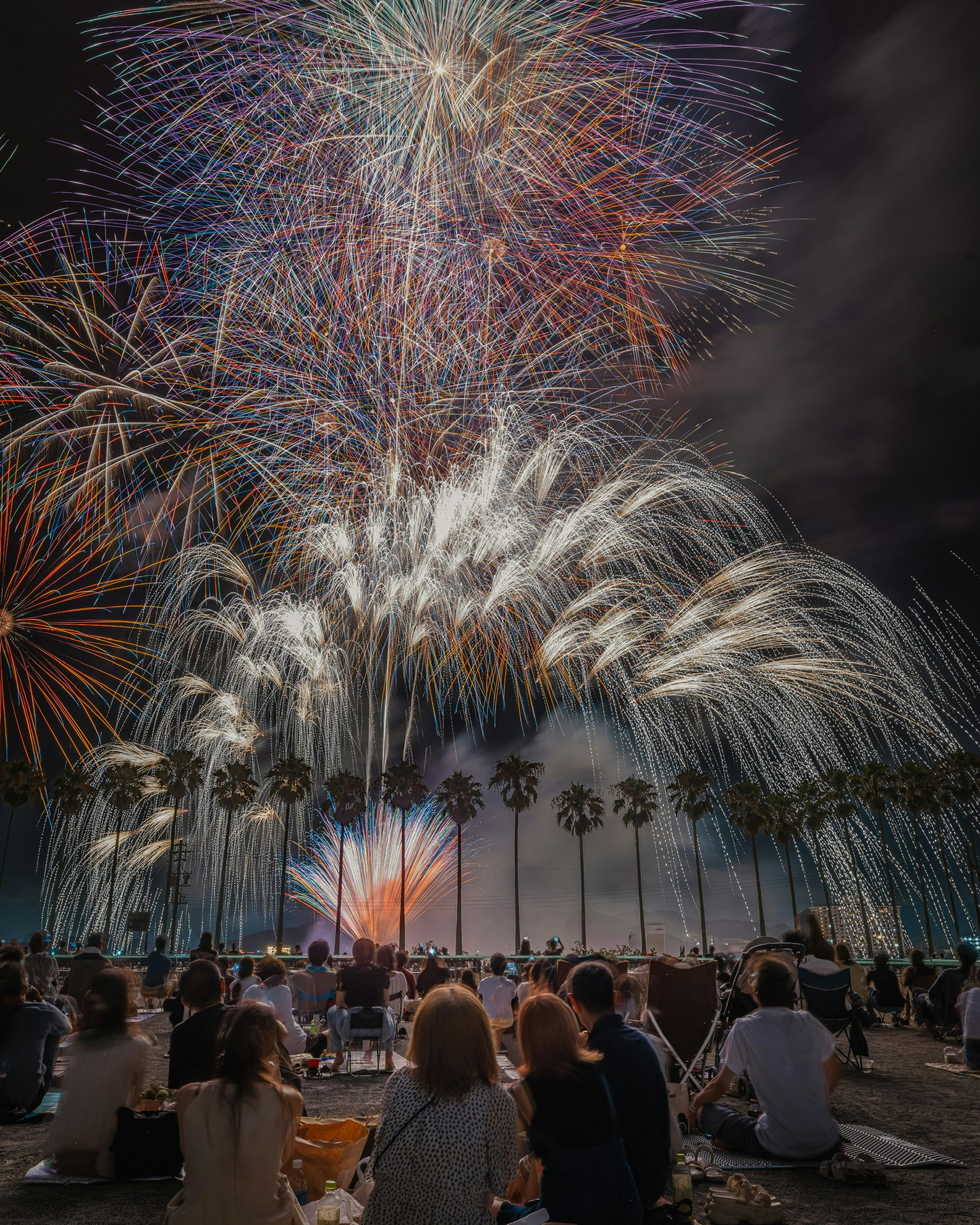 夏の花火を見上げる人々と打ち上げ花火の夜空