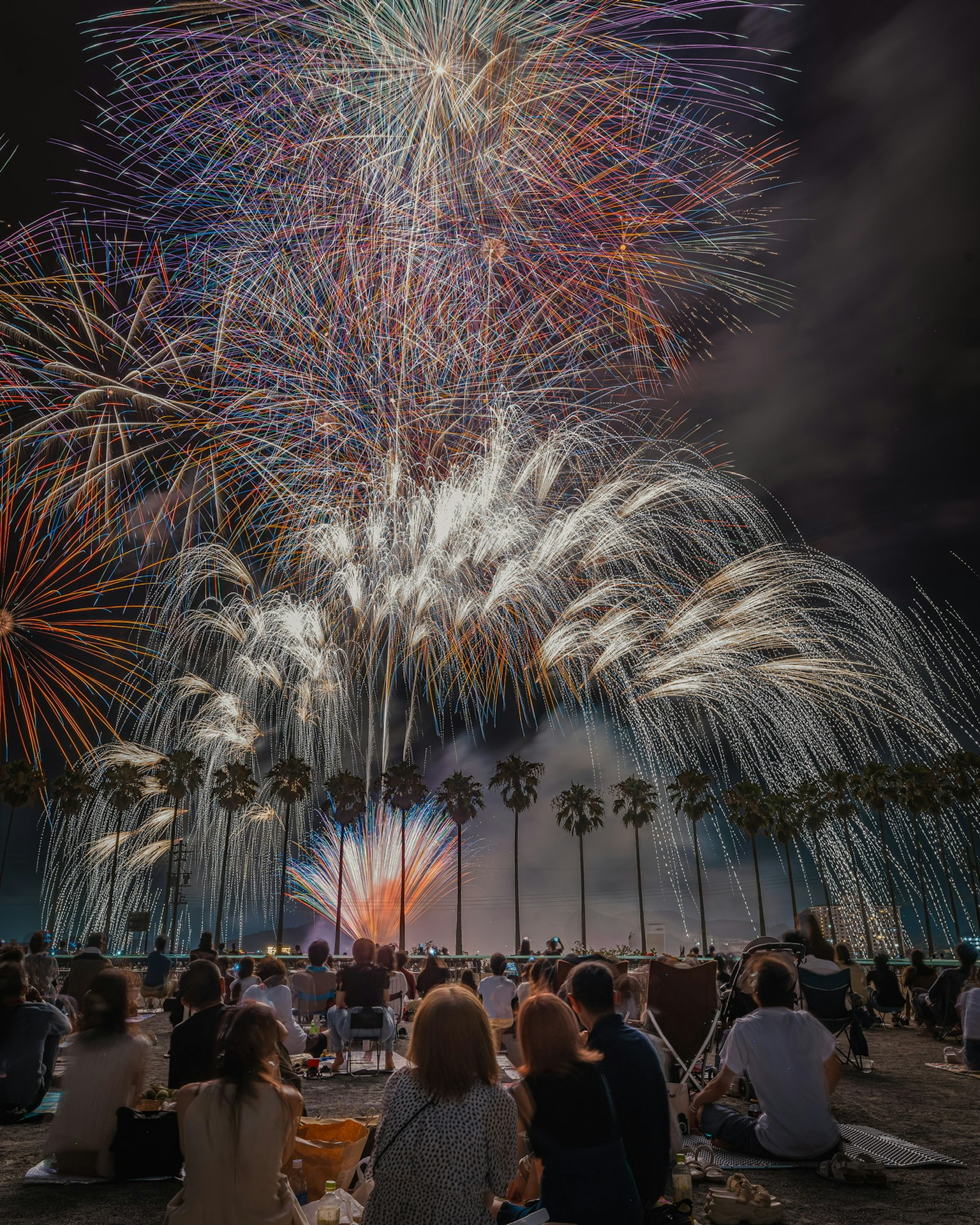 Ein lebhaftes Feuerwerk, das den Nachthimmel erleuchtet, während Zuschauer die Aussicht genießen