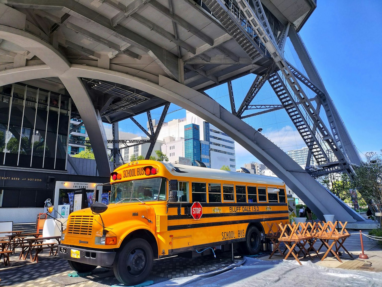 รถบัสโรงเรียนสีเหลืองจอดอยู่ใต้ตึกทันสมัย