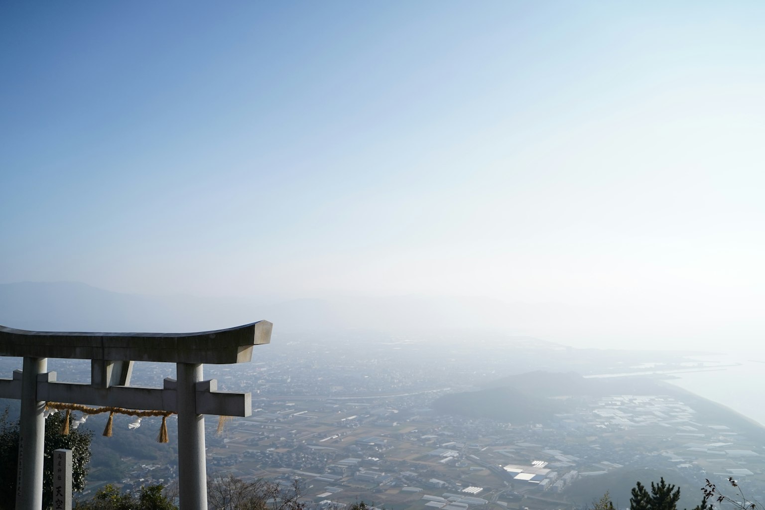 一座鸟居俯瞰着朦胧的风景和蓝天