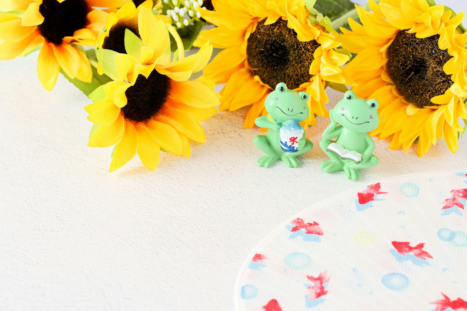 Des tournesols brillants et des figurines de grenouilles vertes créent une scène colorée