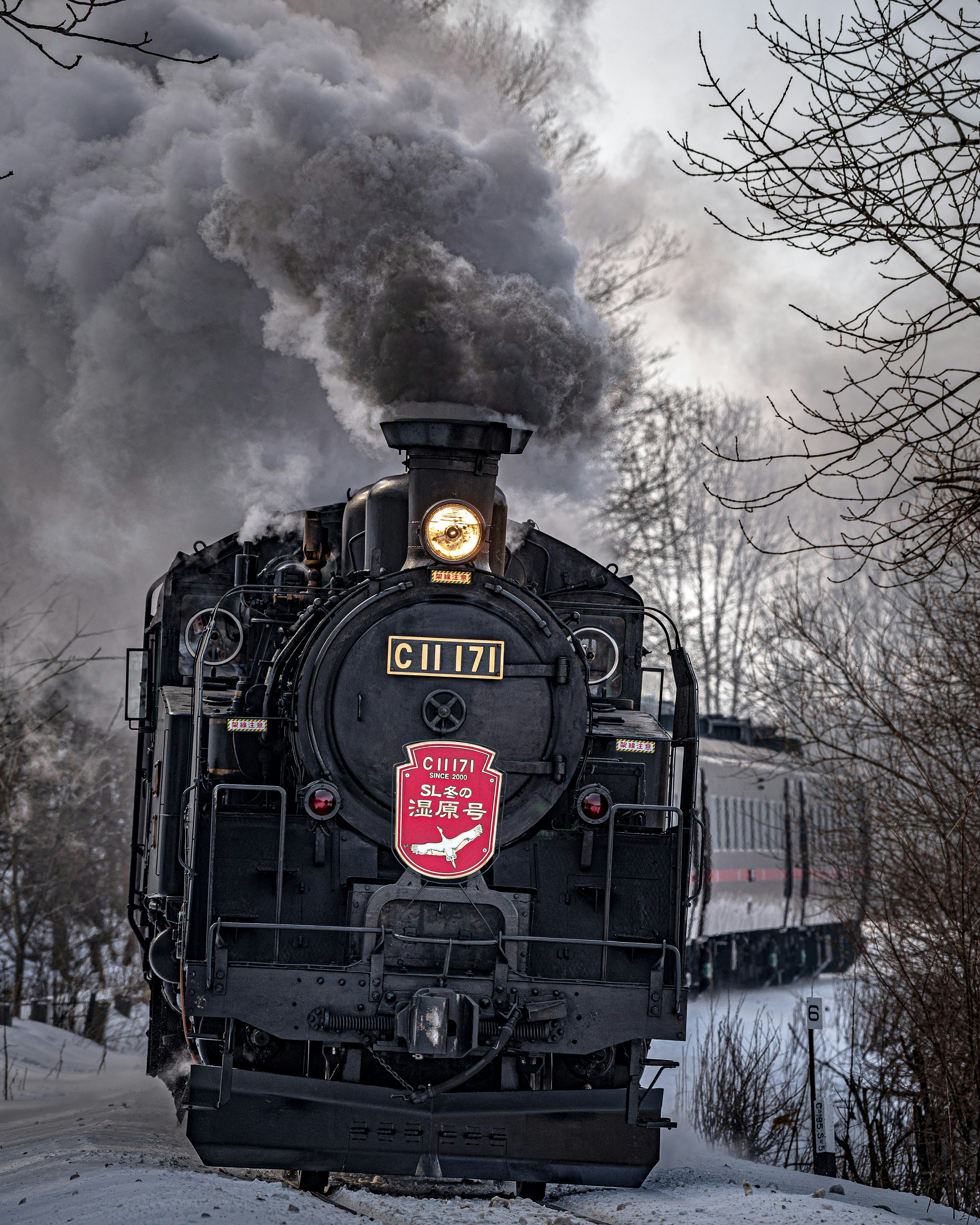 Front view of a steam locomotive running through snowy winter scenery