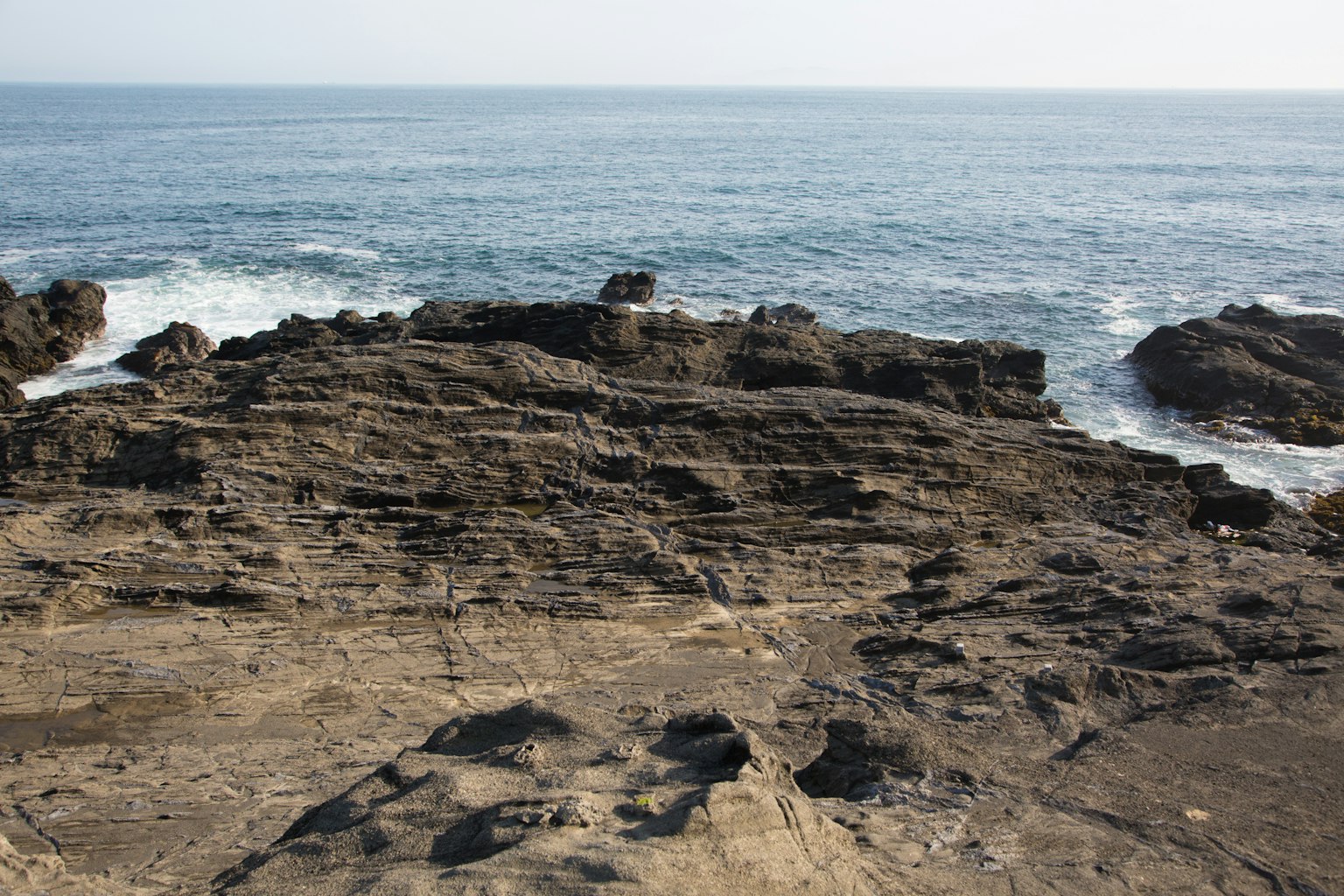 Pesisir berbatu dengan ombak yang menghantam pantai