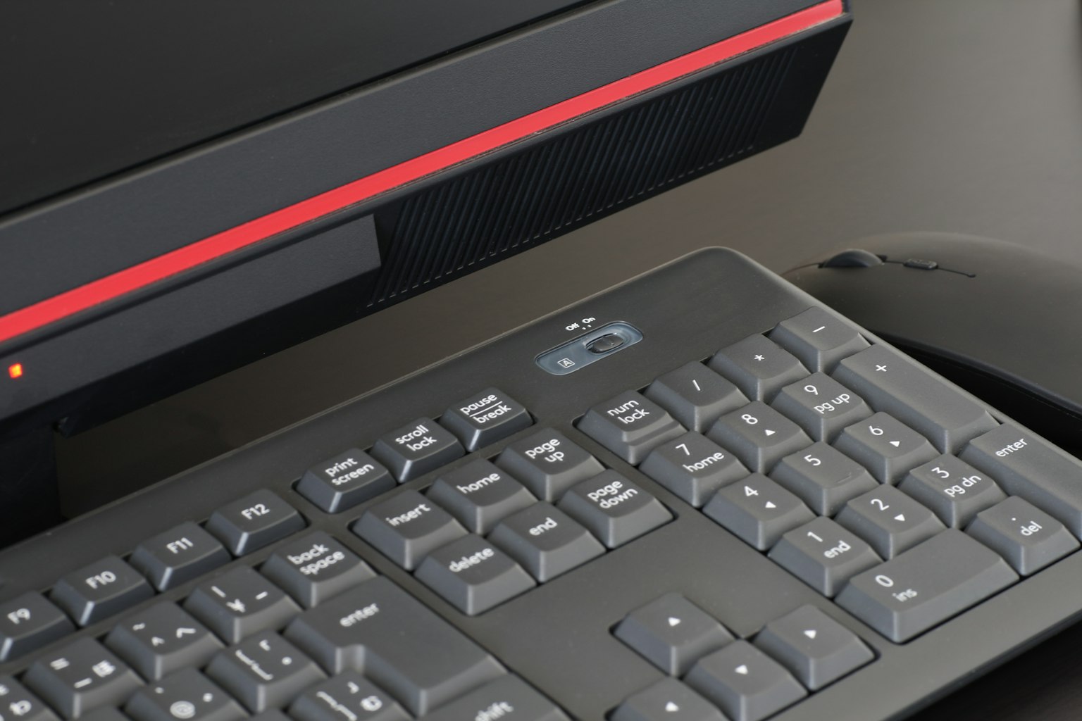 Acercamiento a un teclado negro con un acento rojo en una computadora