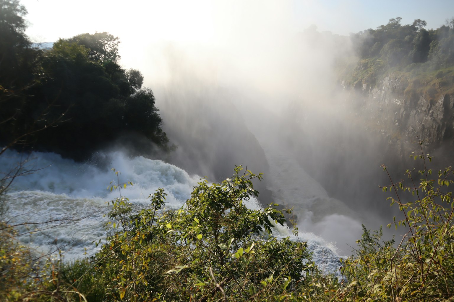Air terjun megah dilihat dari atas dengan kabut dan air yang mengalir