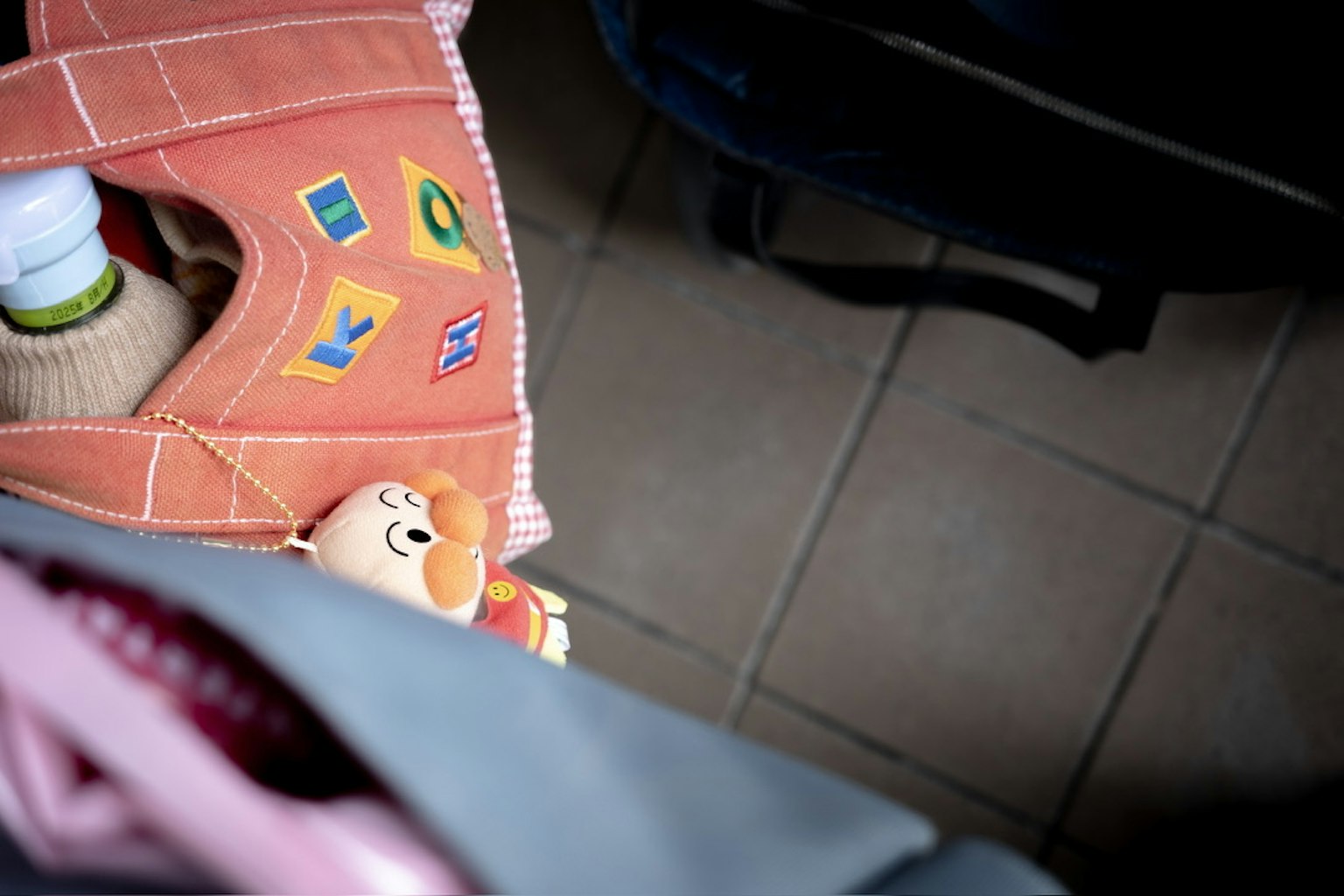 Colorful bag with patches and a toy peeking out