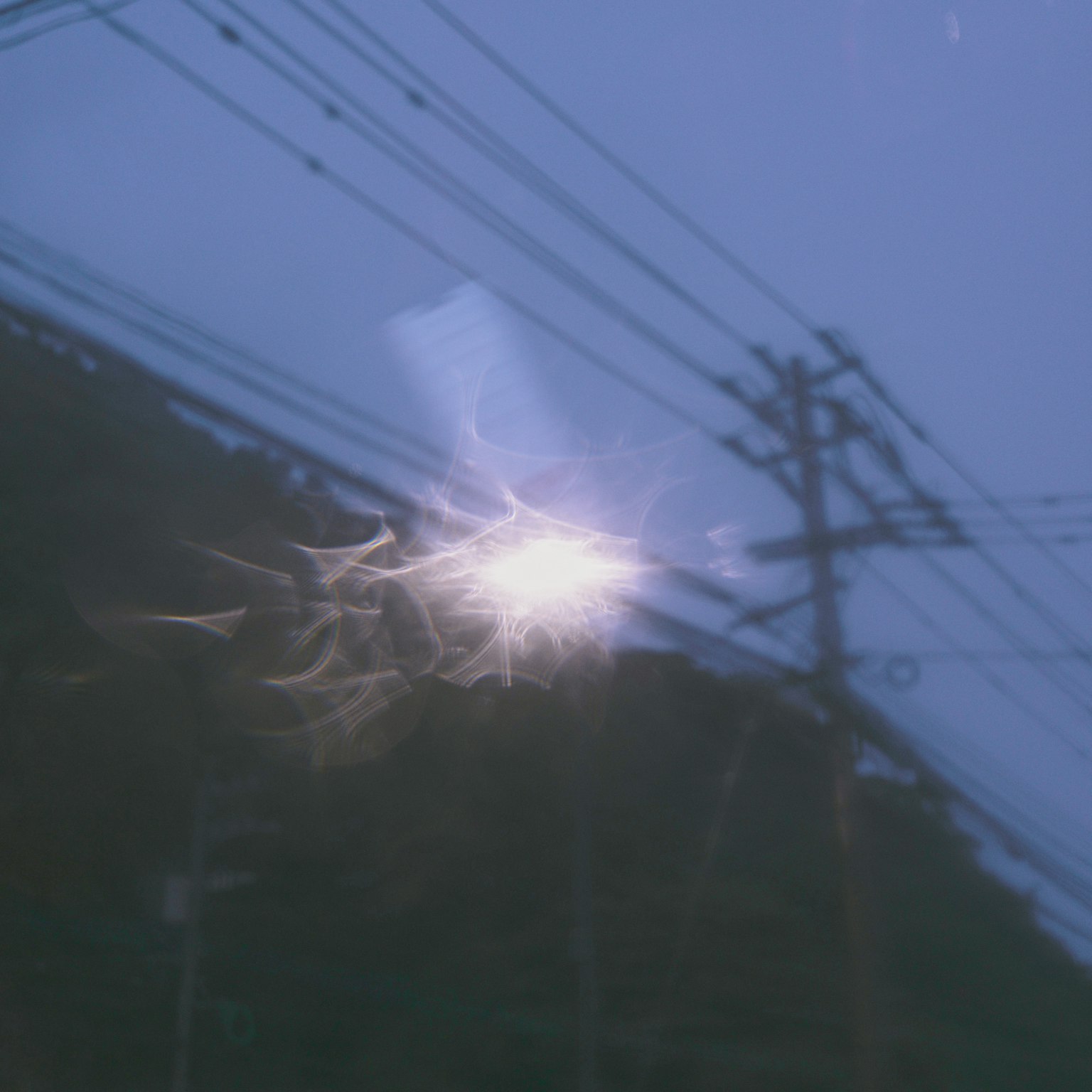 在黑暗夜空中映射在电线和电柱上的神秘光芒