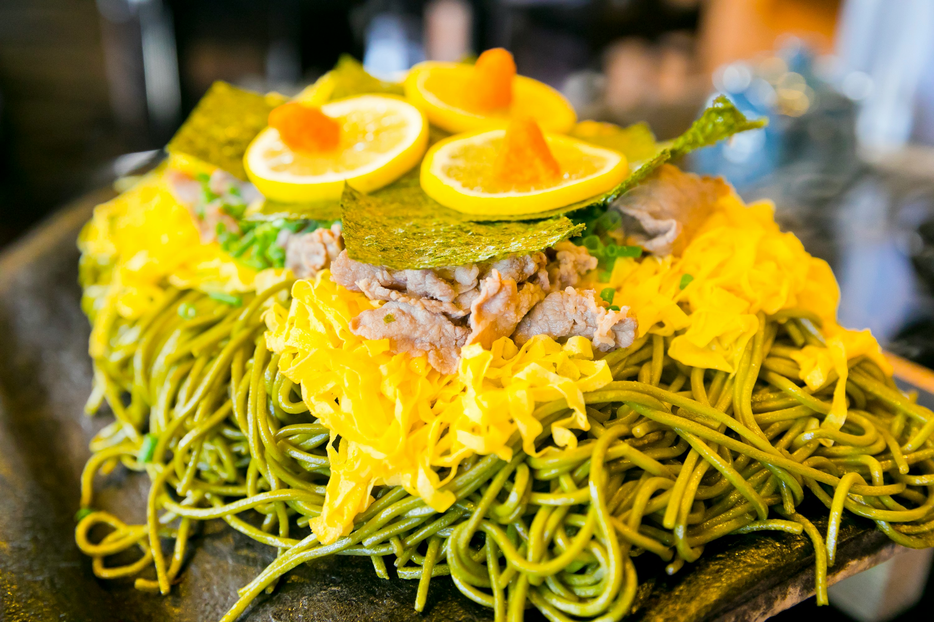 Plate of yellow noodles topped with lemon slices