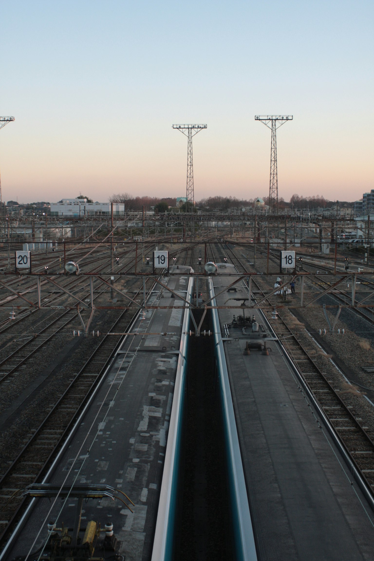 Railroad tracks and power poles under a sunset sky