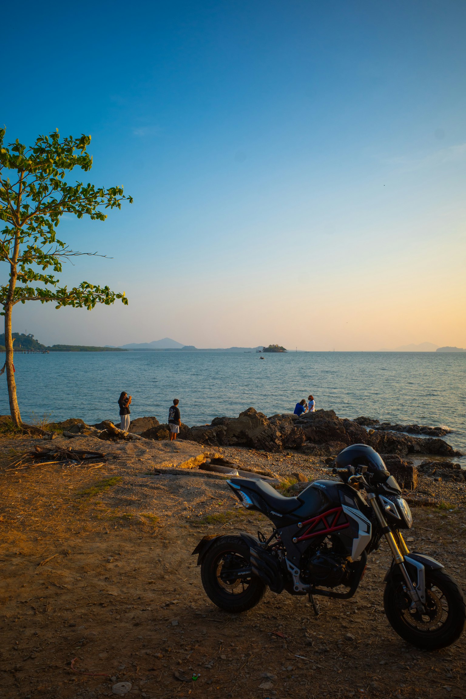 停在海邊的摩托車與日落背景