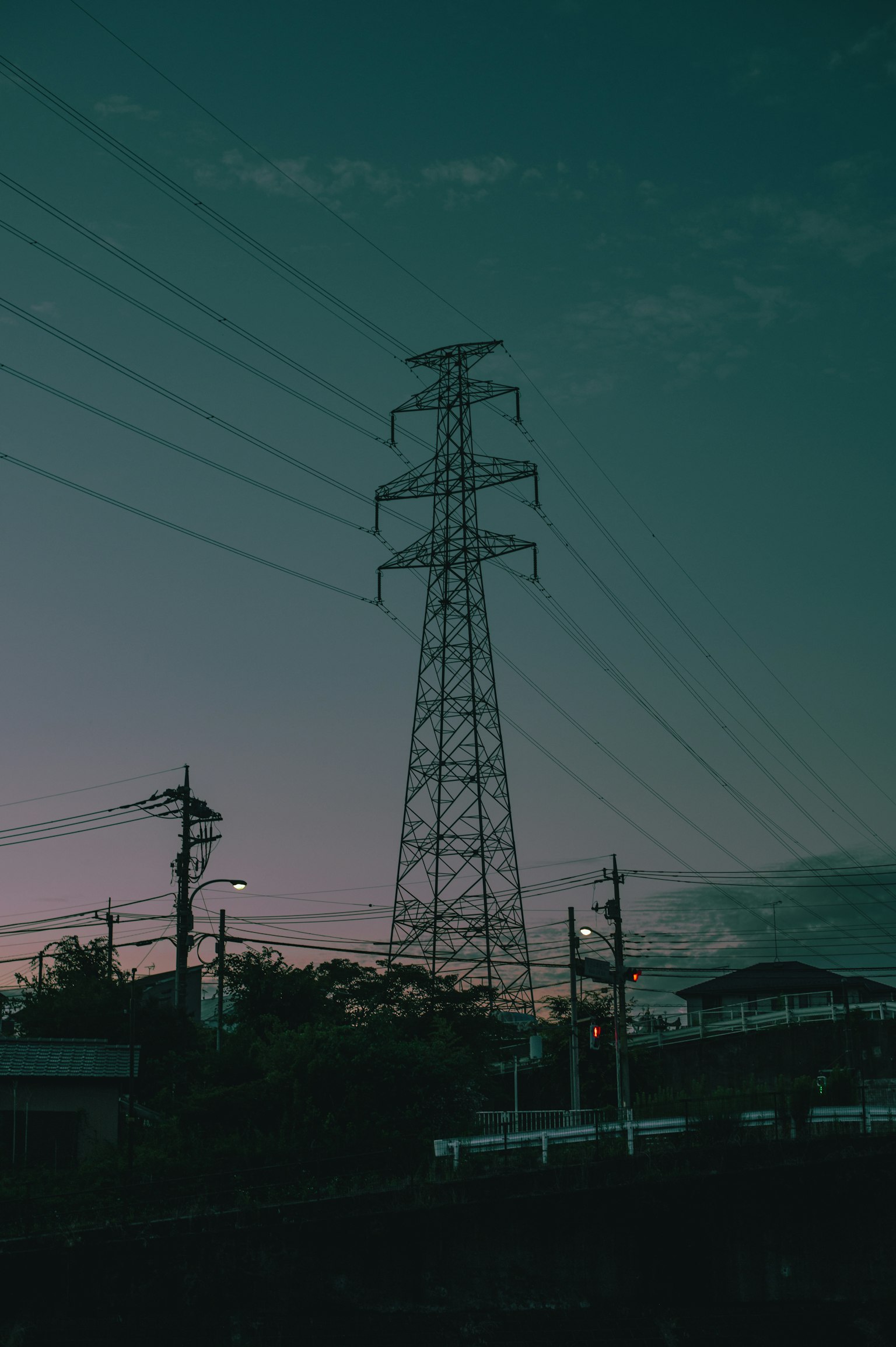 Silhouette d'un poteau électrique et de lignes électriques au crépuscule