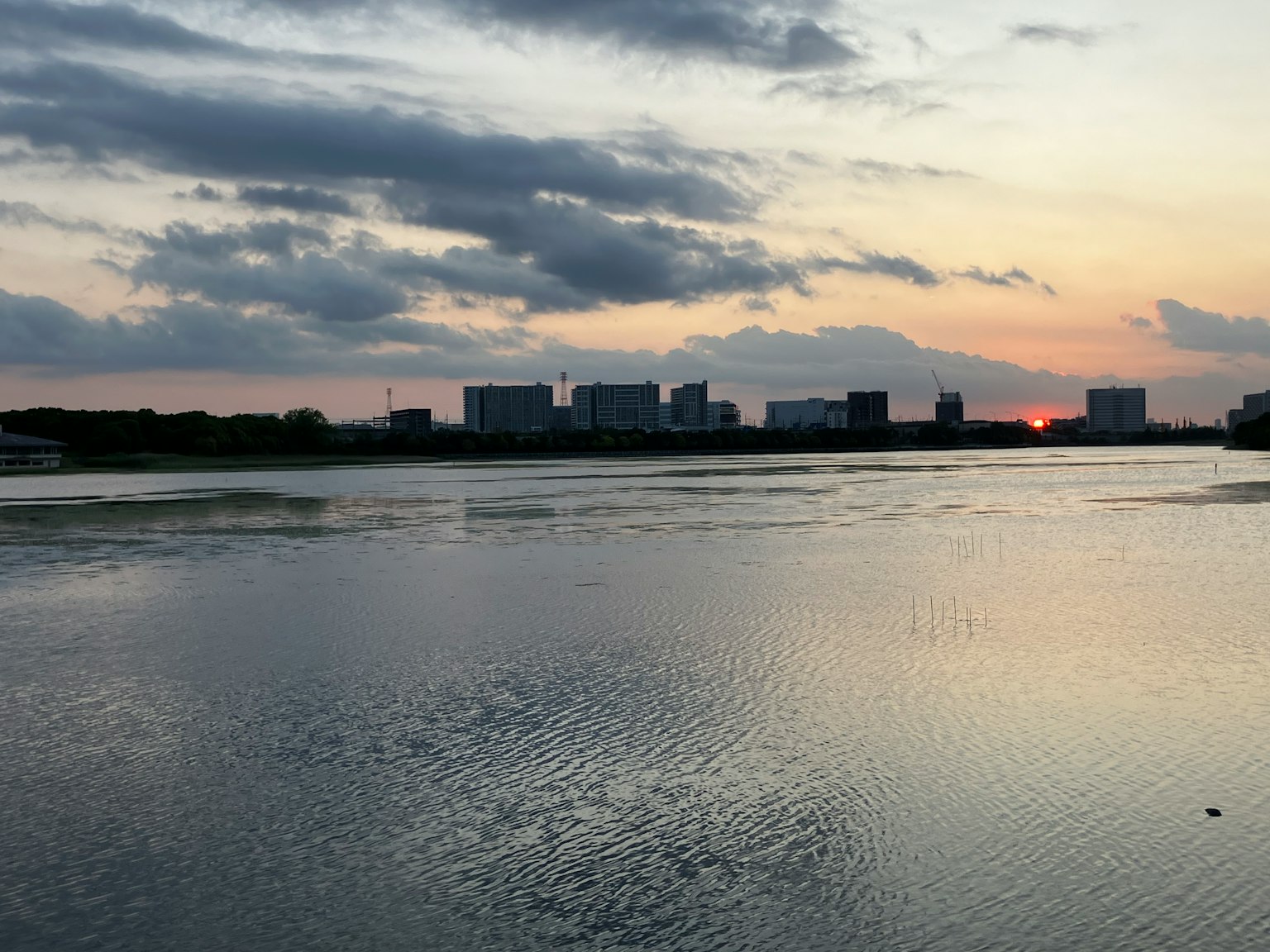 Silhouette di edifici che si riflettono sull'acqua al tramonto