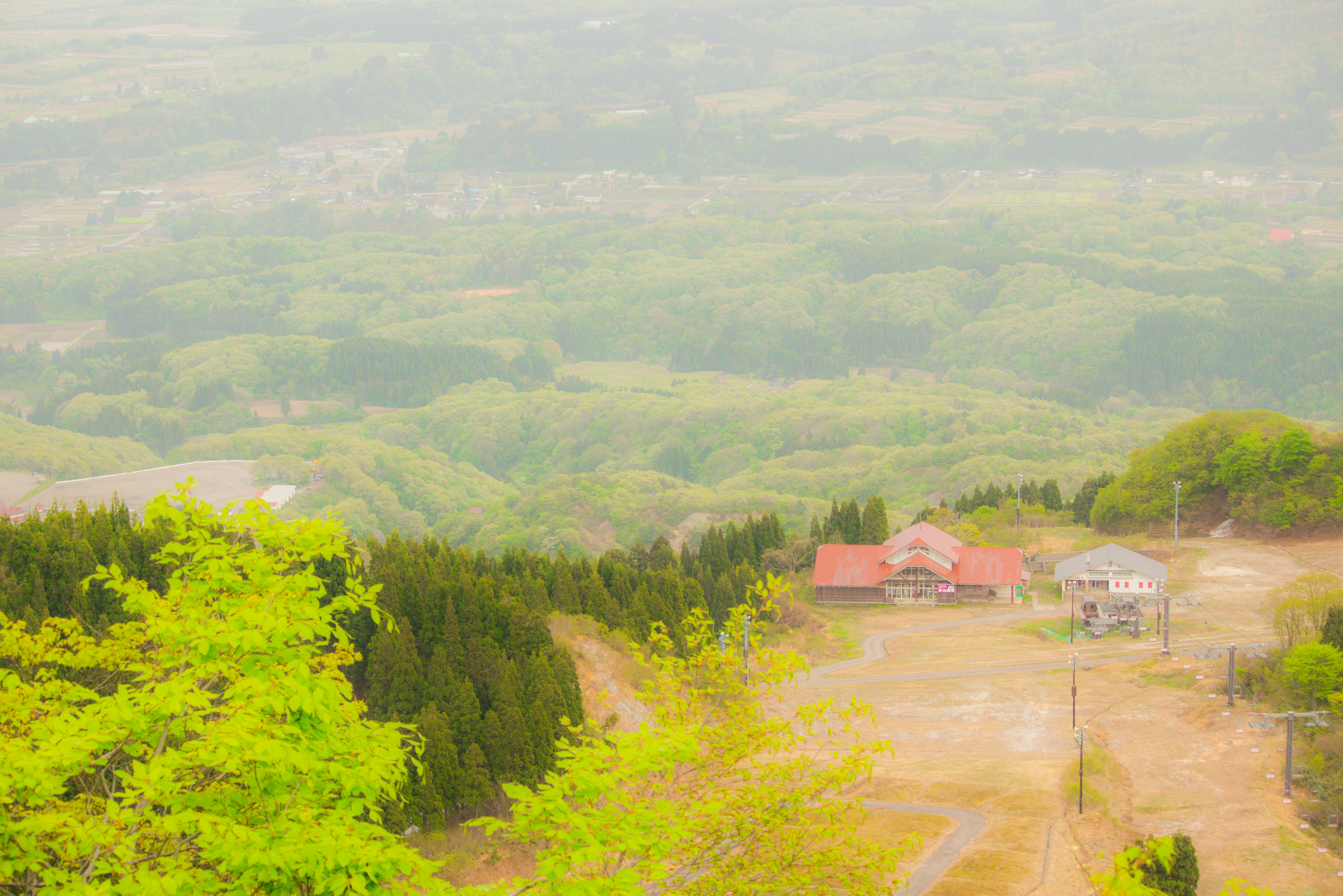 緑の丘陵と山あいの集落を見下ろす眺め