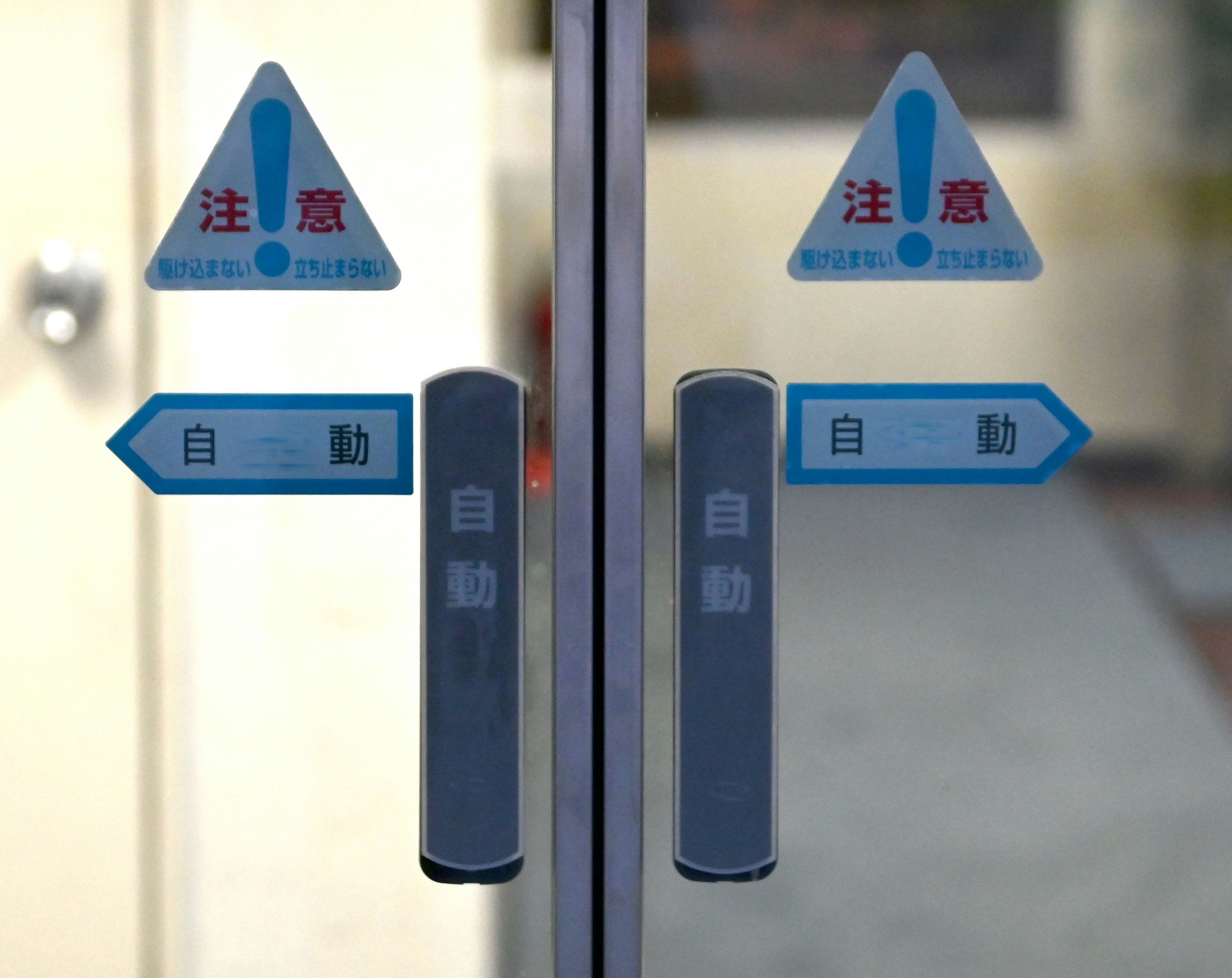 注意表示と「自動」矢印が並ぶ交通案内のサイン