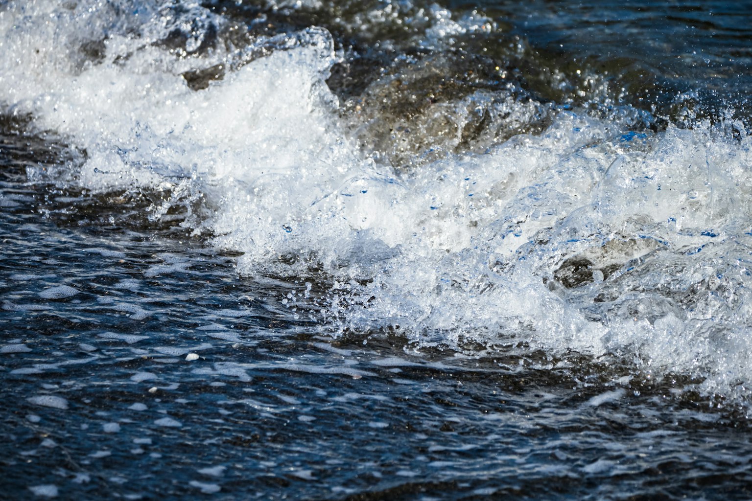 Nahaufnahme von Ozeanwellen mit schäumenden weißen Spitzen und dunklem Wasser