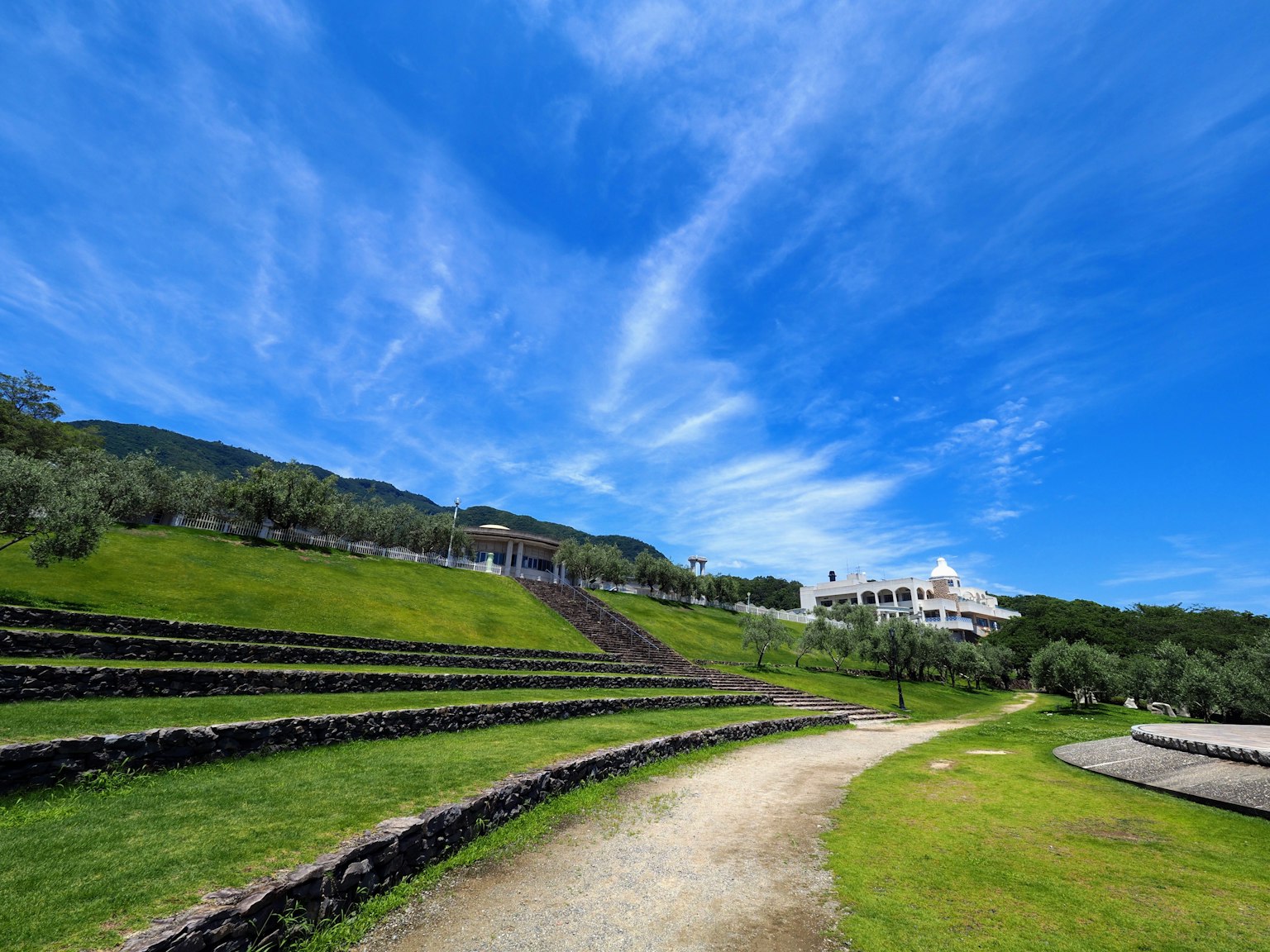 綠色山丘上石階小道的風景 在藍天之下